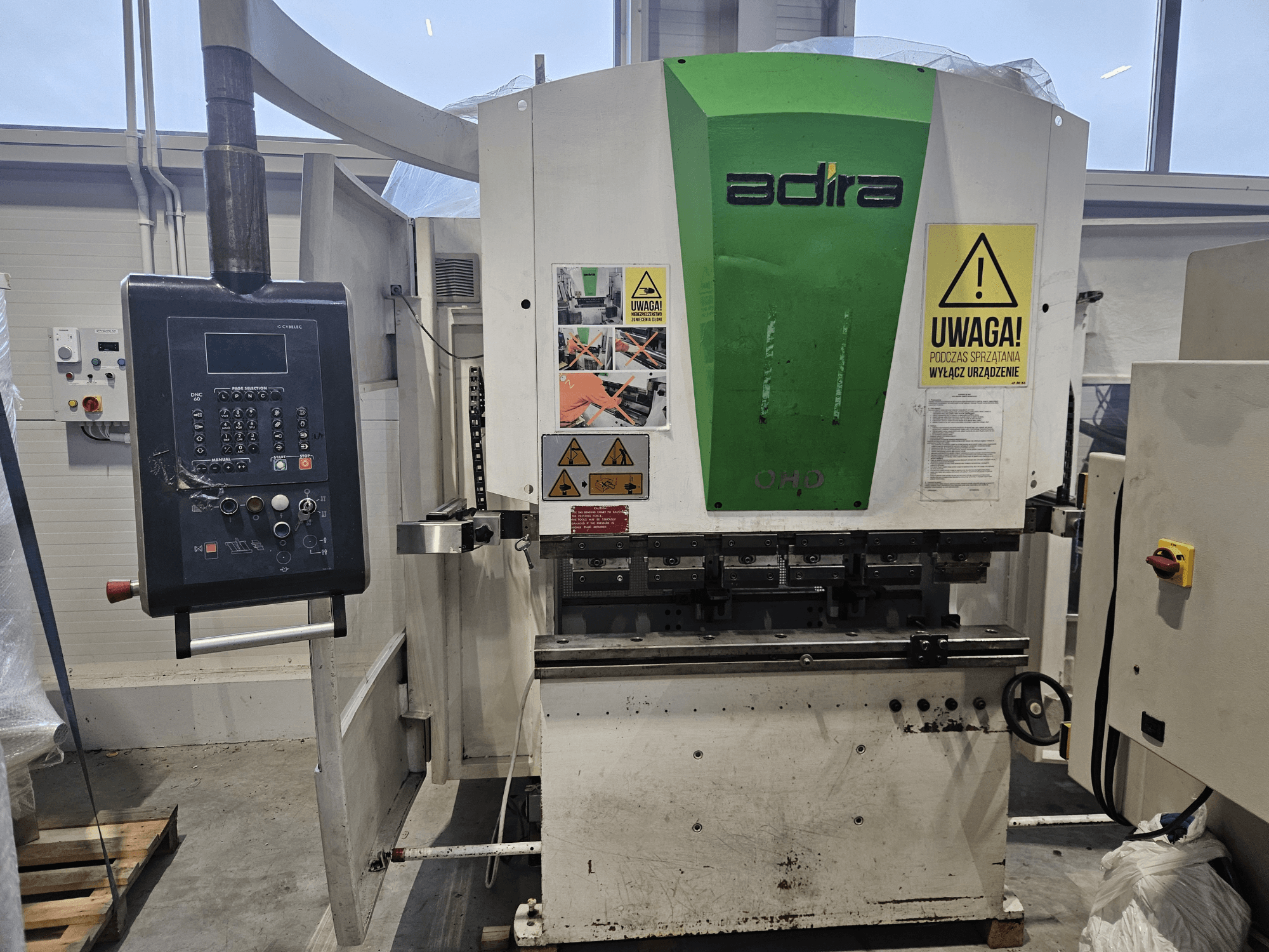 Adira OHD machine viewed from the front, featuring a control panel, safety warnings, and operational buttons.