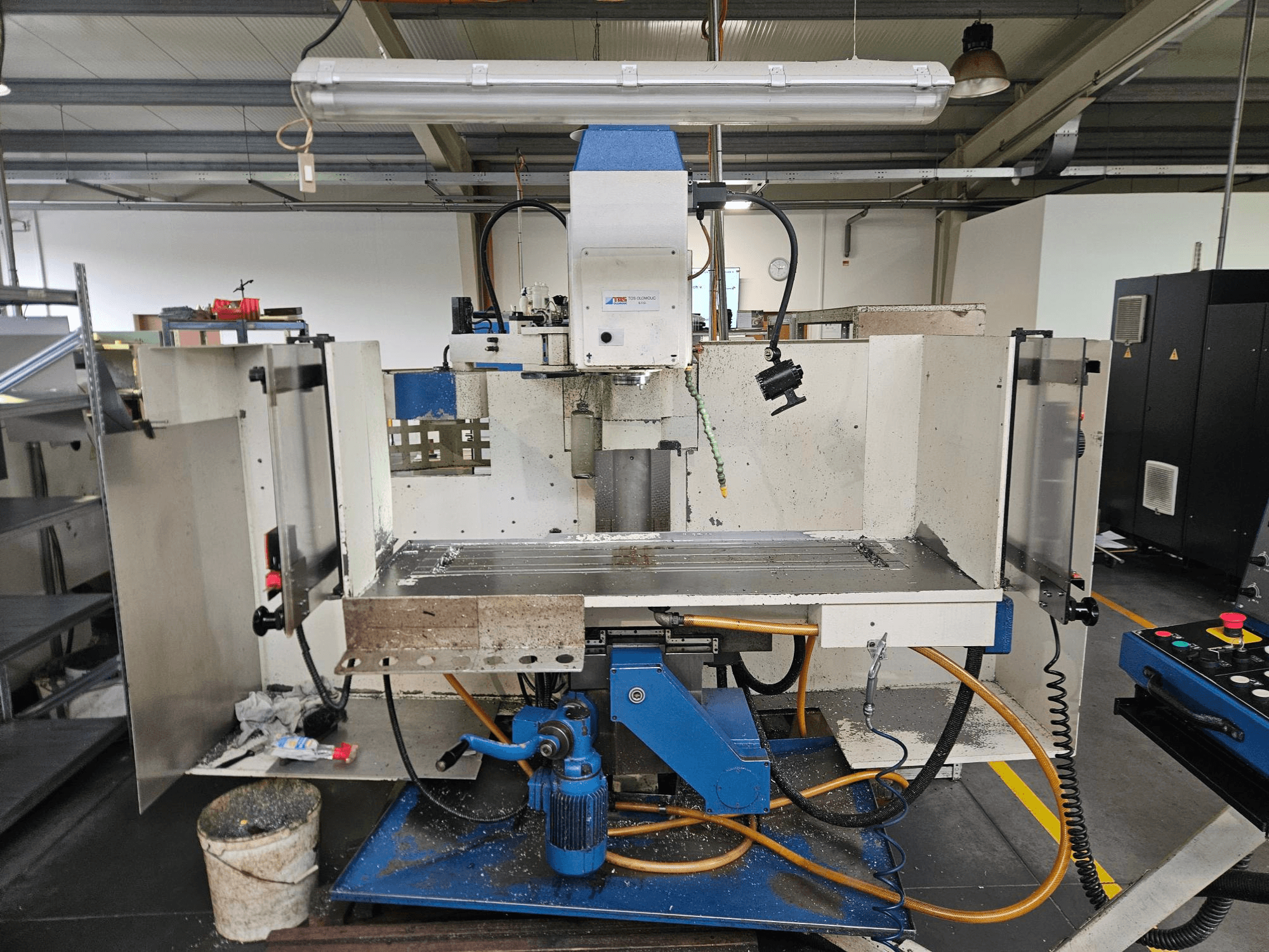 TOS Olomouc FV30 CNC A vertical machining centre in a workshop, front view showing control panel, worktable, and coolant system.