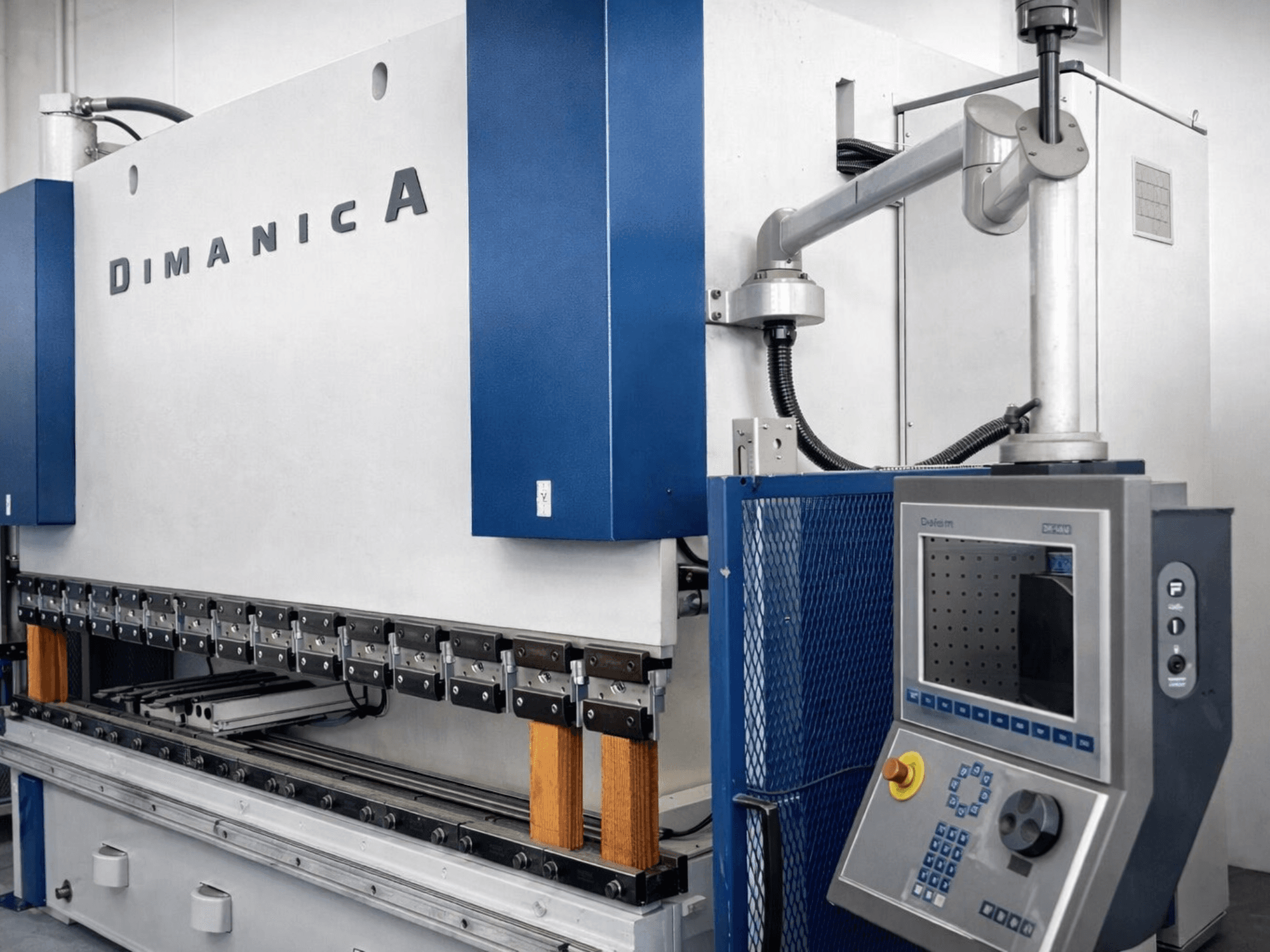 Press brake DINAMICA 3000x100 by Warcom, side view showcasing control panel and bending tools for metal fabrication.