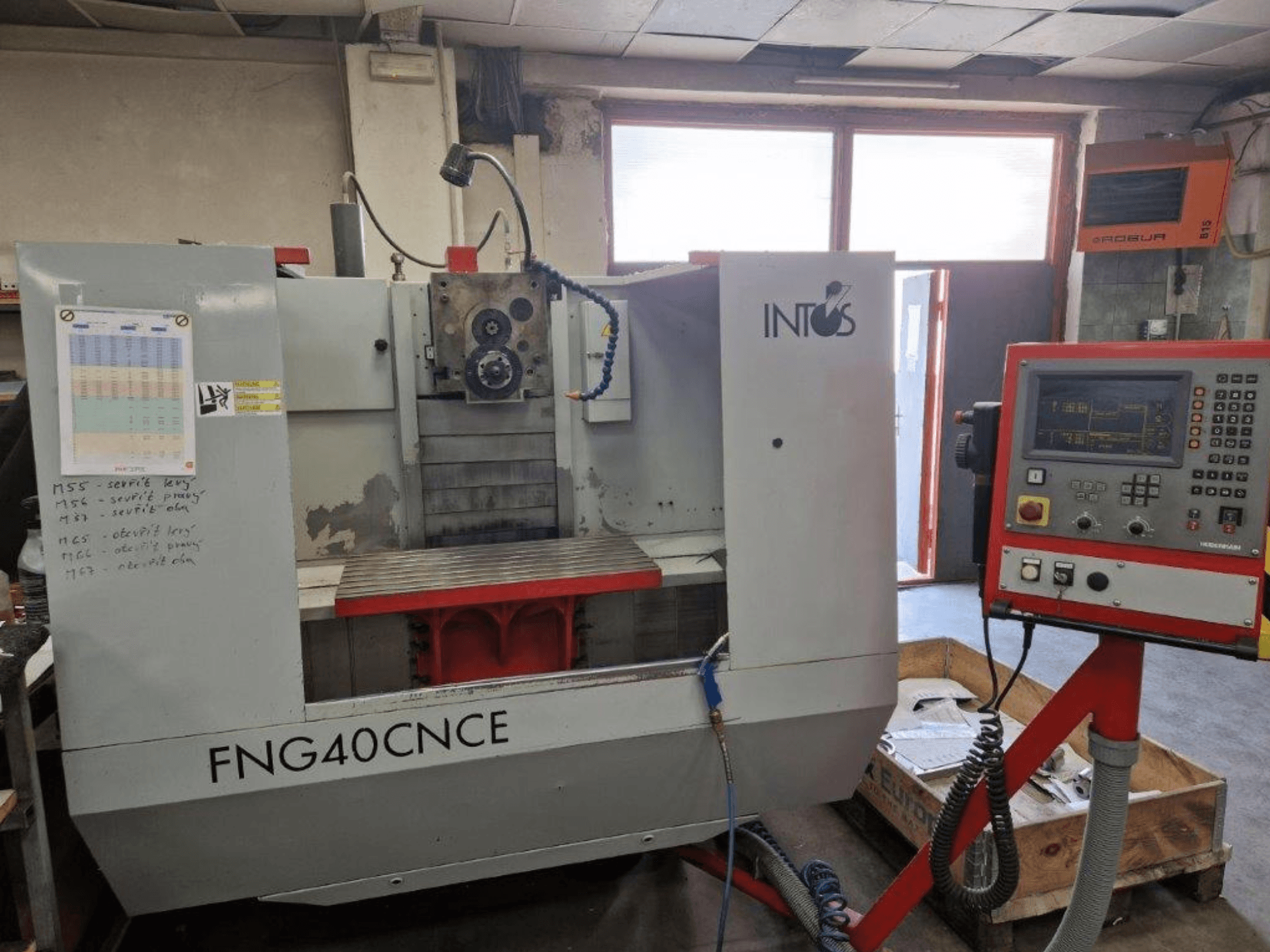 INTOS FNG40CNC machine, front view, features control panel, operational parts, and a metal worktable. Ideal for machining.