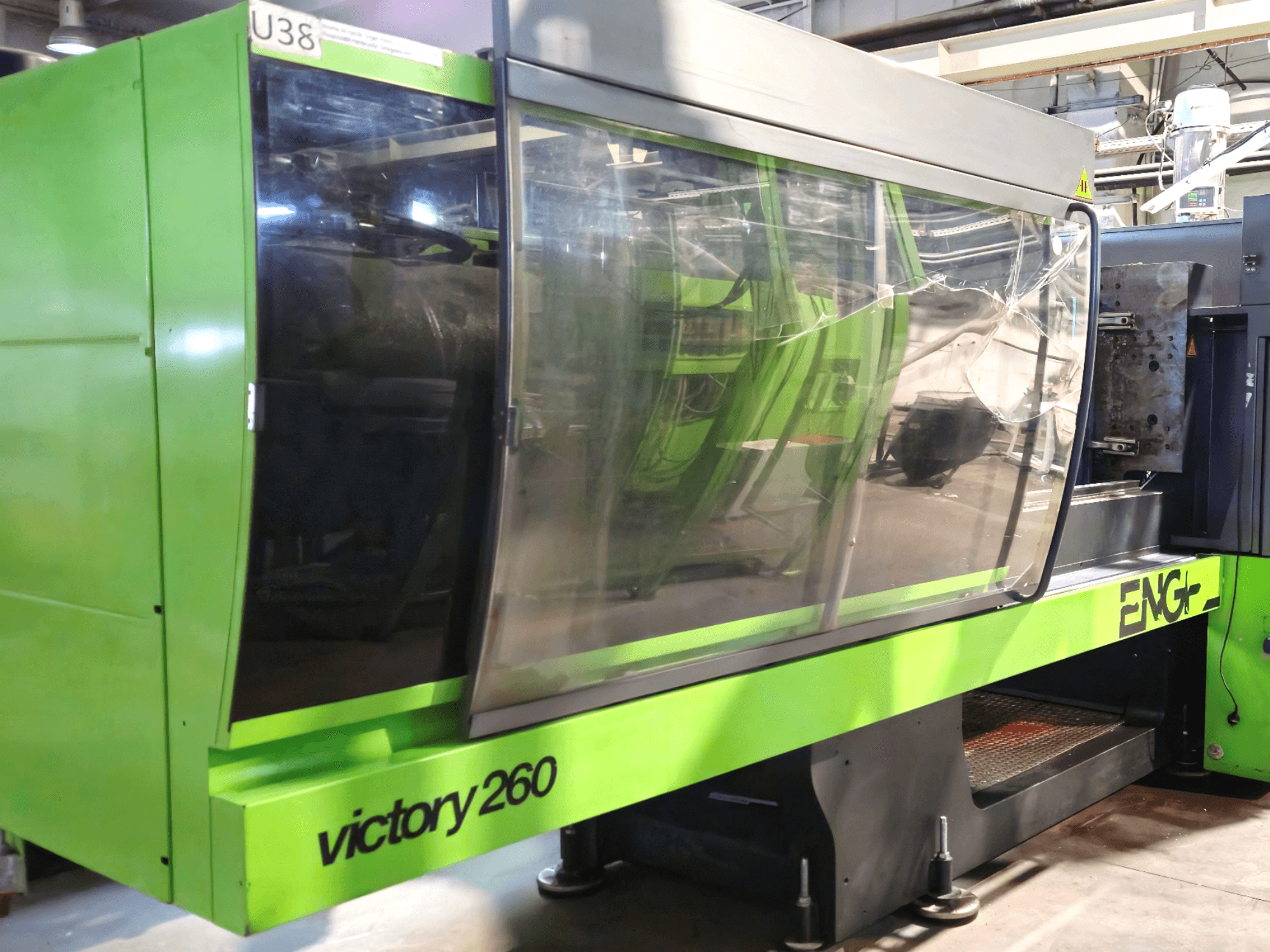 ENG victory 260 injection molding machine, front view; features a green exterior and large glass panel for visibility.