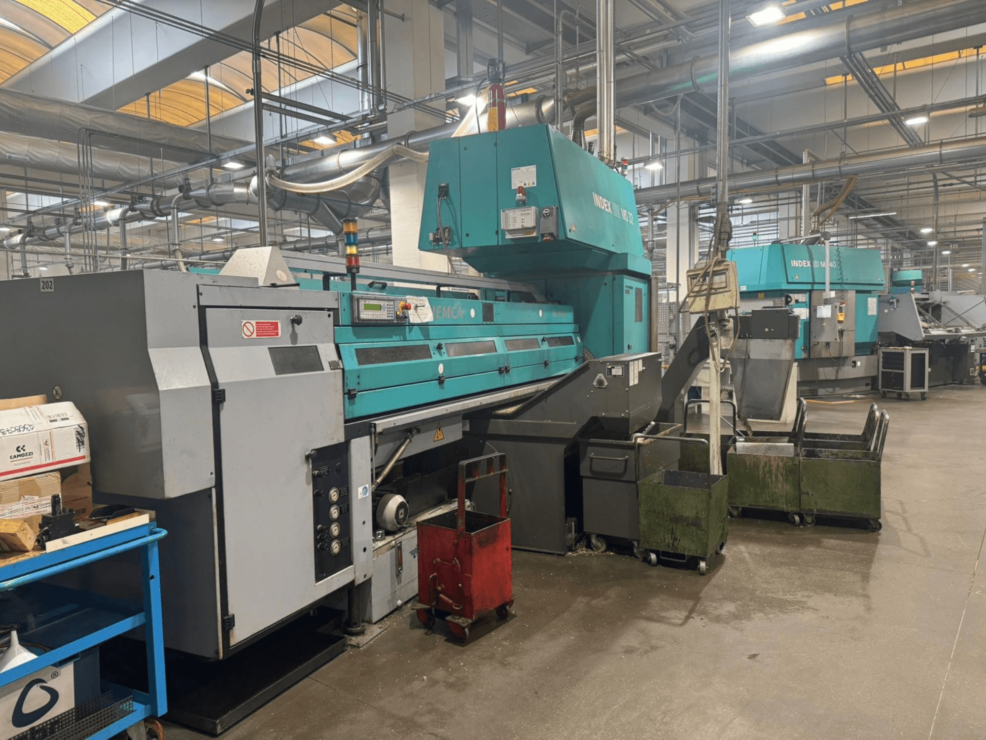 Multi-spindle turning machine, INDEX MS32C, front view showing controls and operational area in a workshop setting.