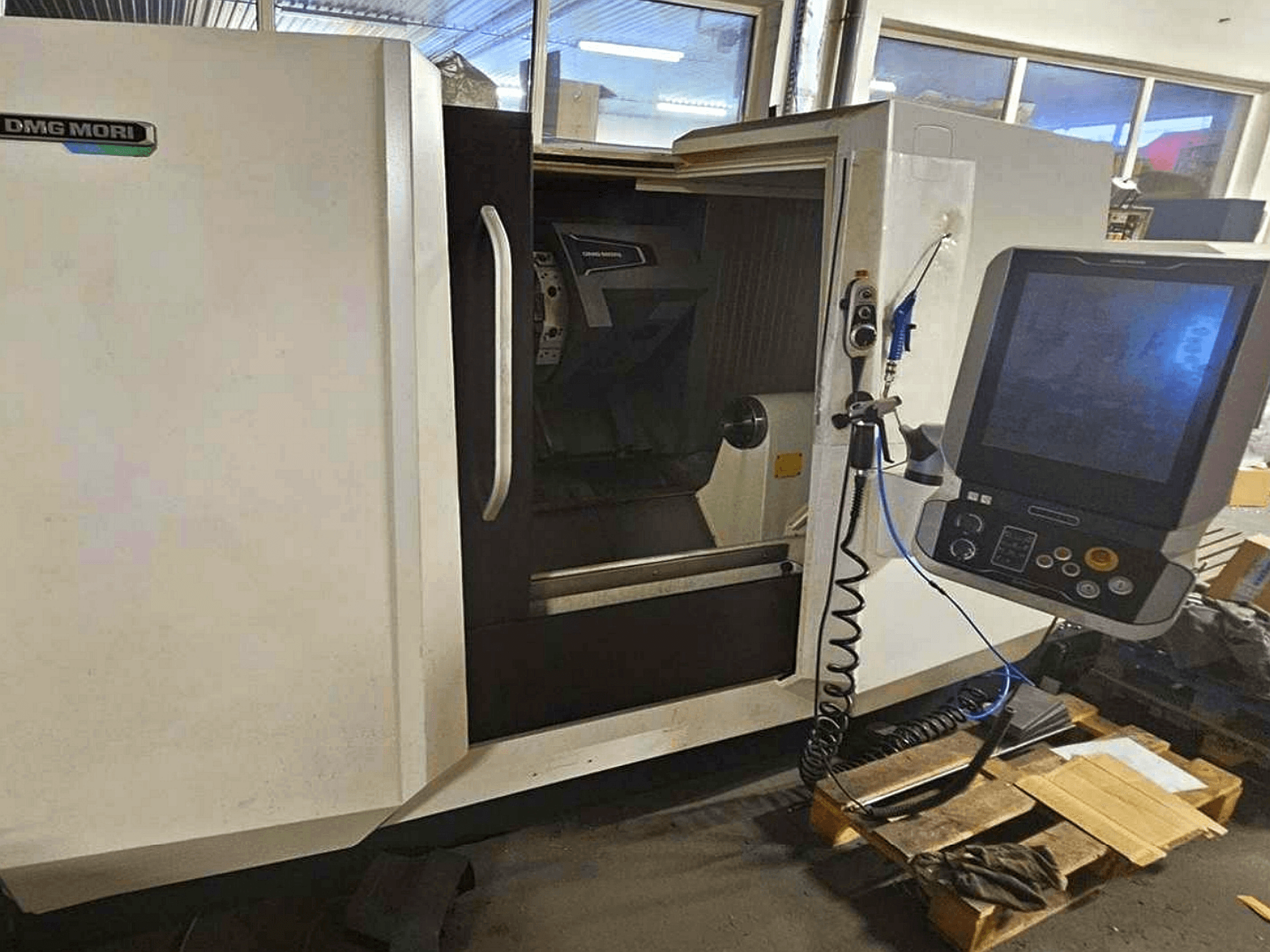 DMG MORI CLX 450 V4 horizontal turning machine, front view with control panel, showcasing the workspace and body design.