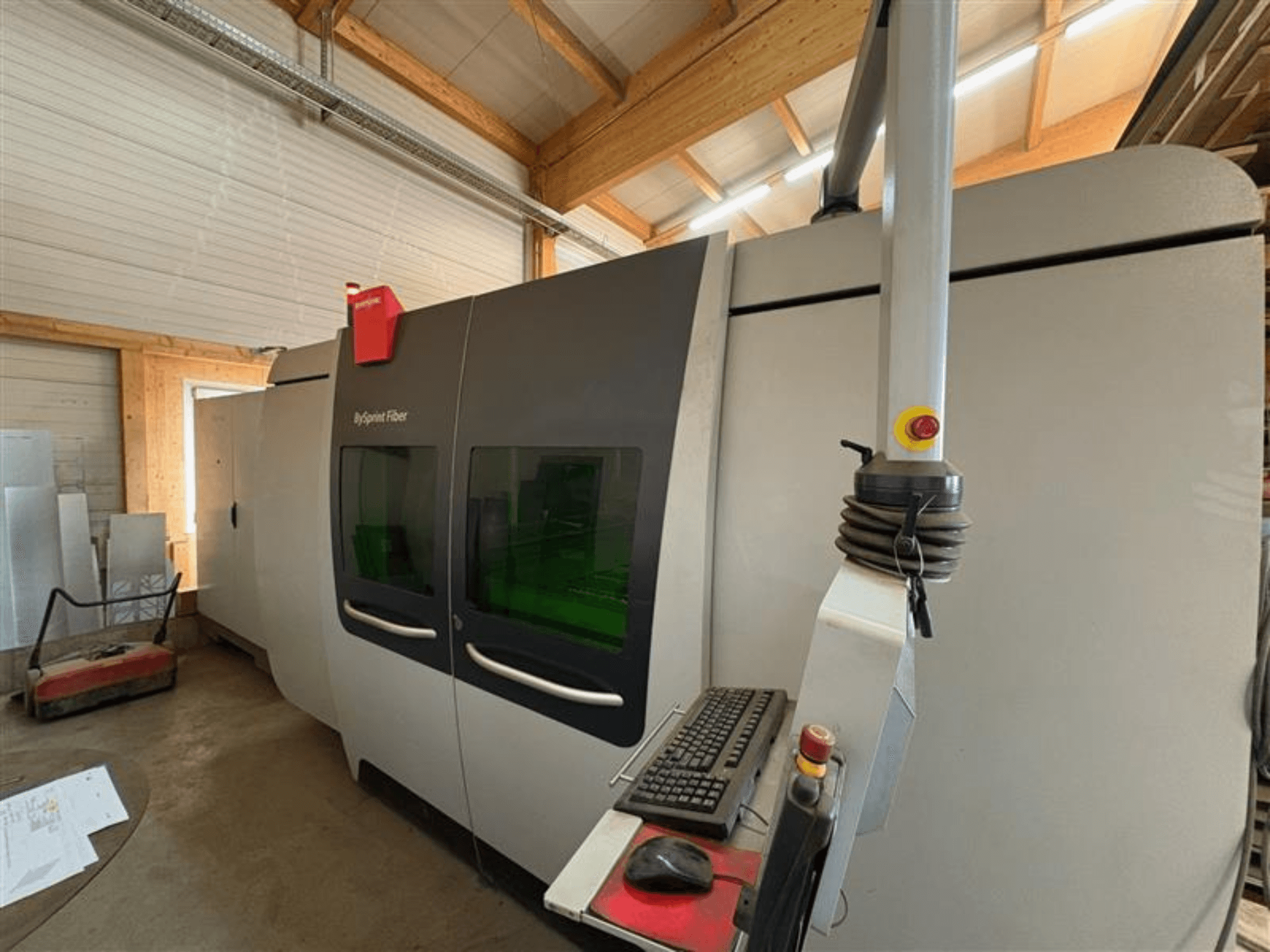 Bystronic ByJet Fiber cutting machine in a workshop, front view showing control panel and dual green viewing windows.