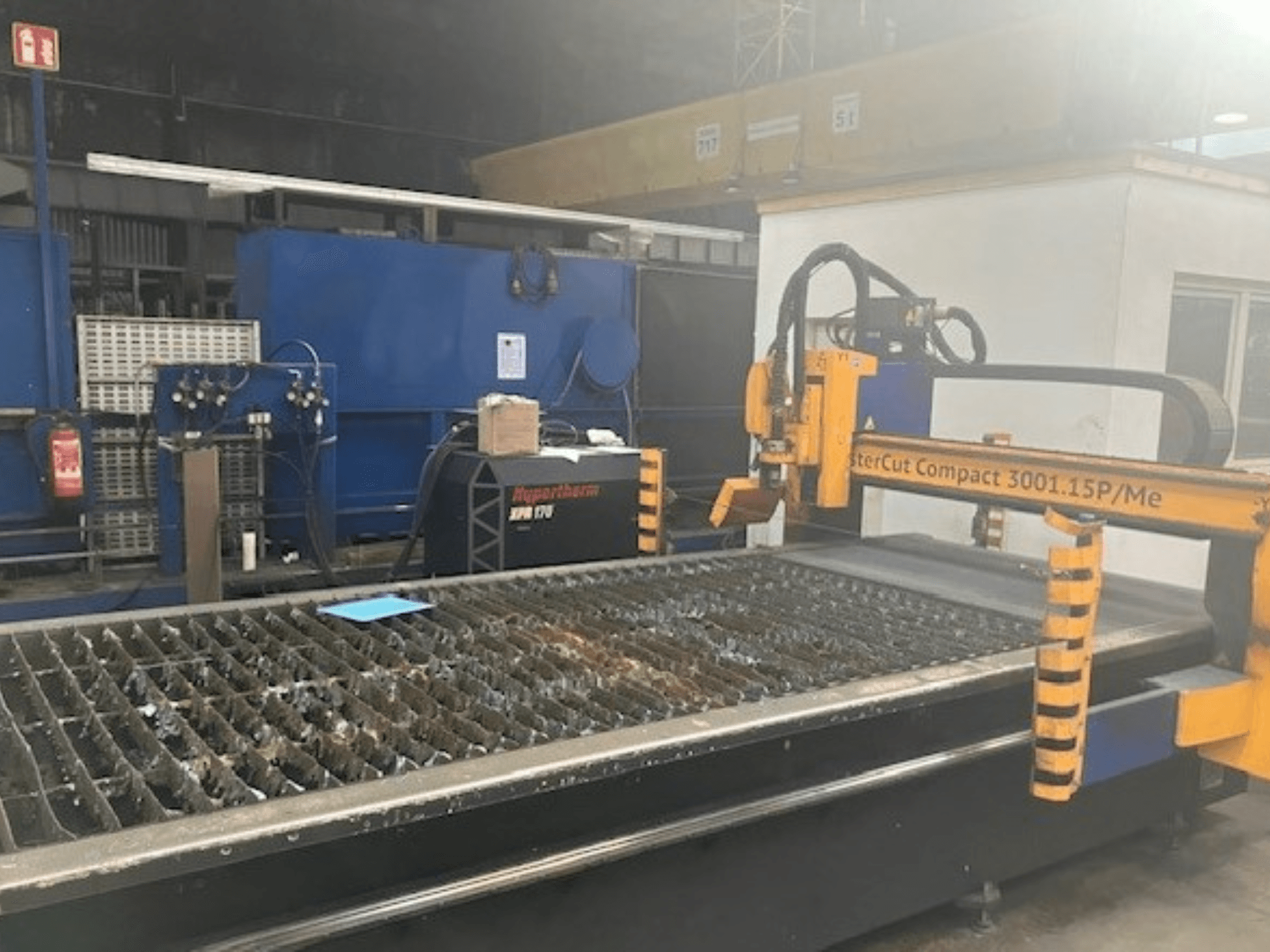 Hypertherm MasterCut Compact 3001.15P/Me plasma cutting machine in side view, showing cutting table and control panel.