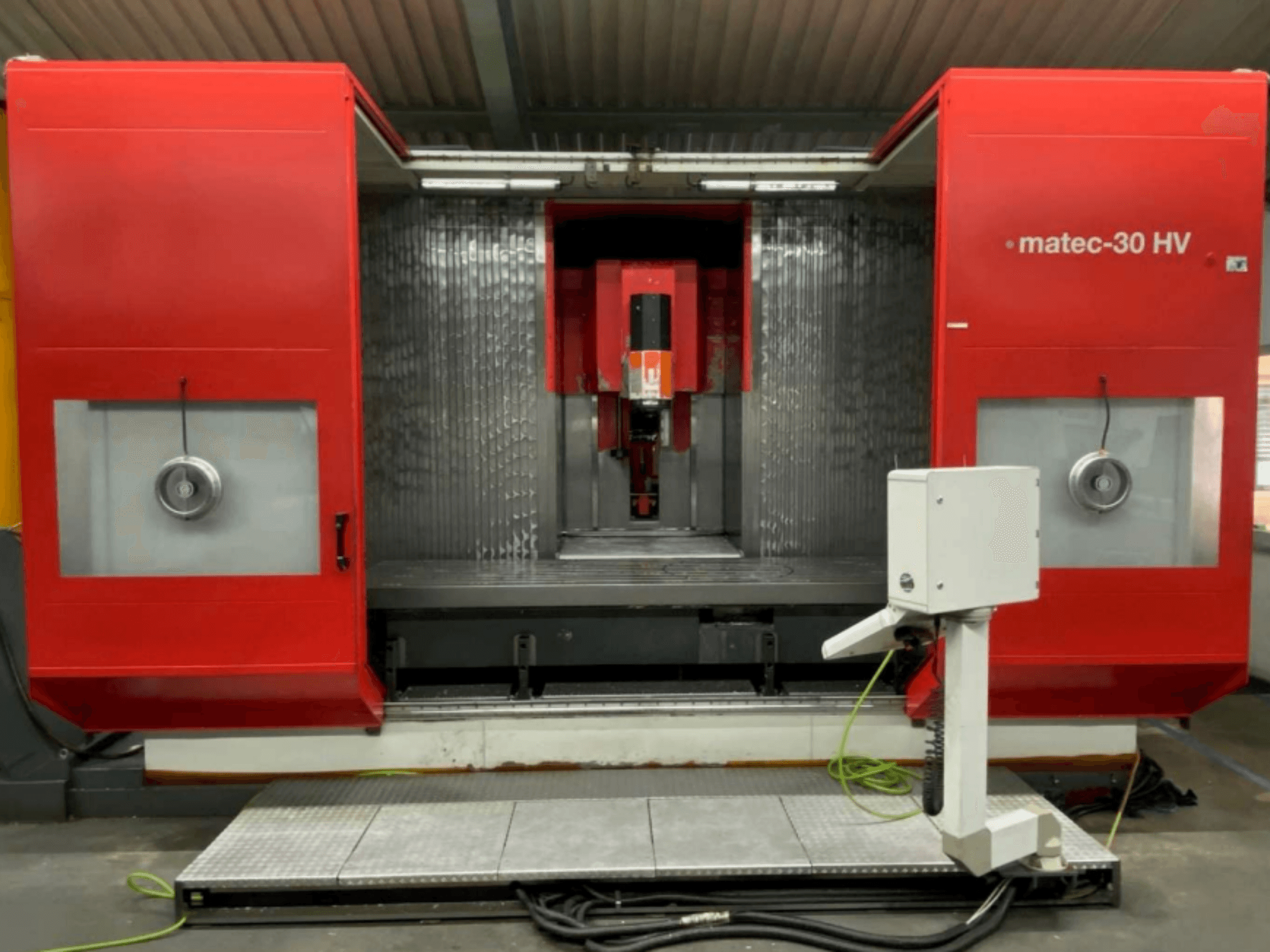 Red matec-30 HV milling machine, front view with control unit and base, showcasing a large work area and precision tools.