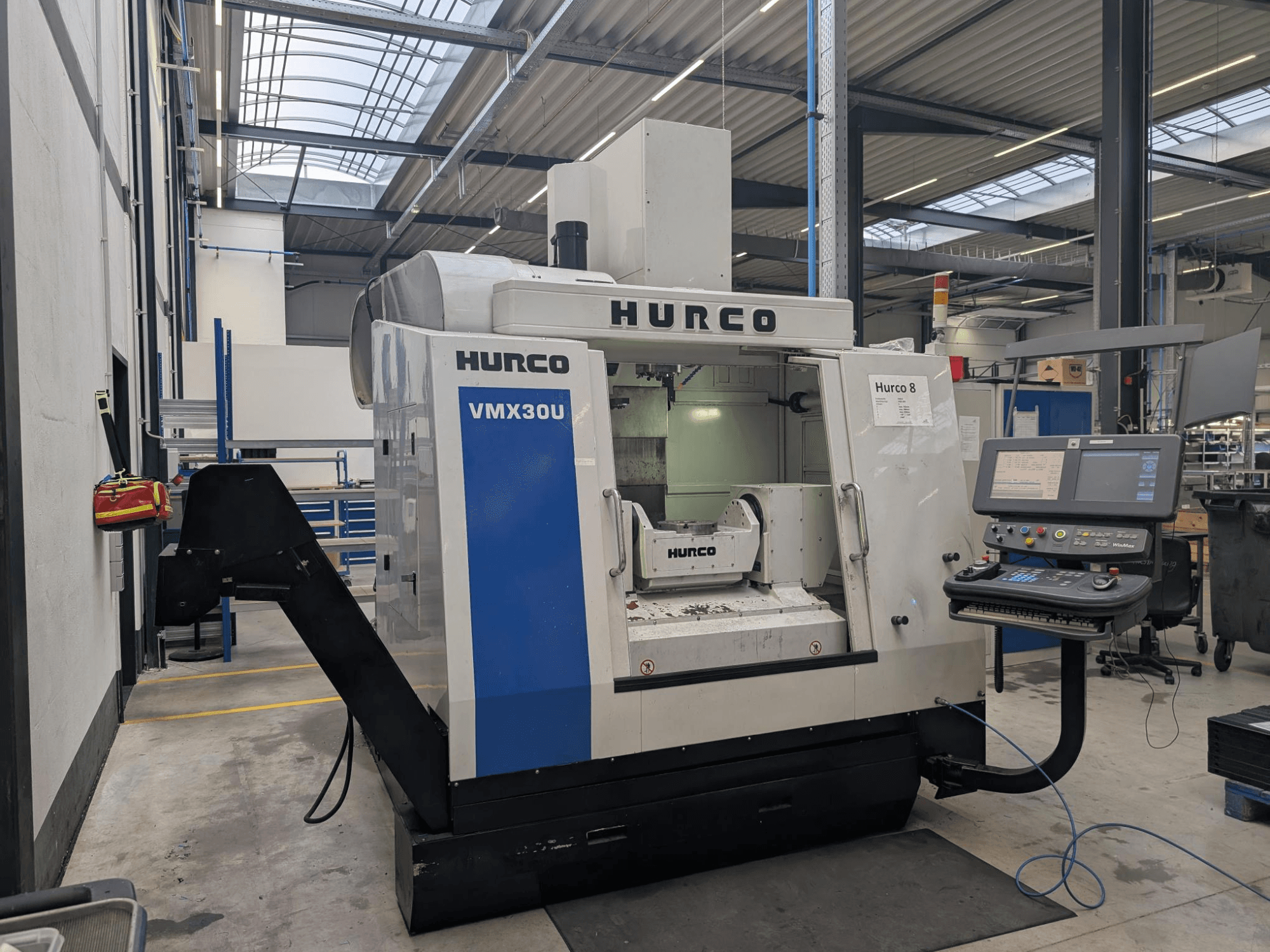 Hurco VMX30U CNC machine in a workshop, front view, featuring control panel with buttons and data display.