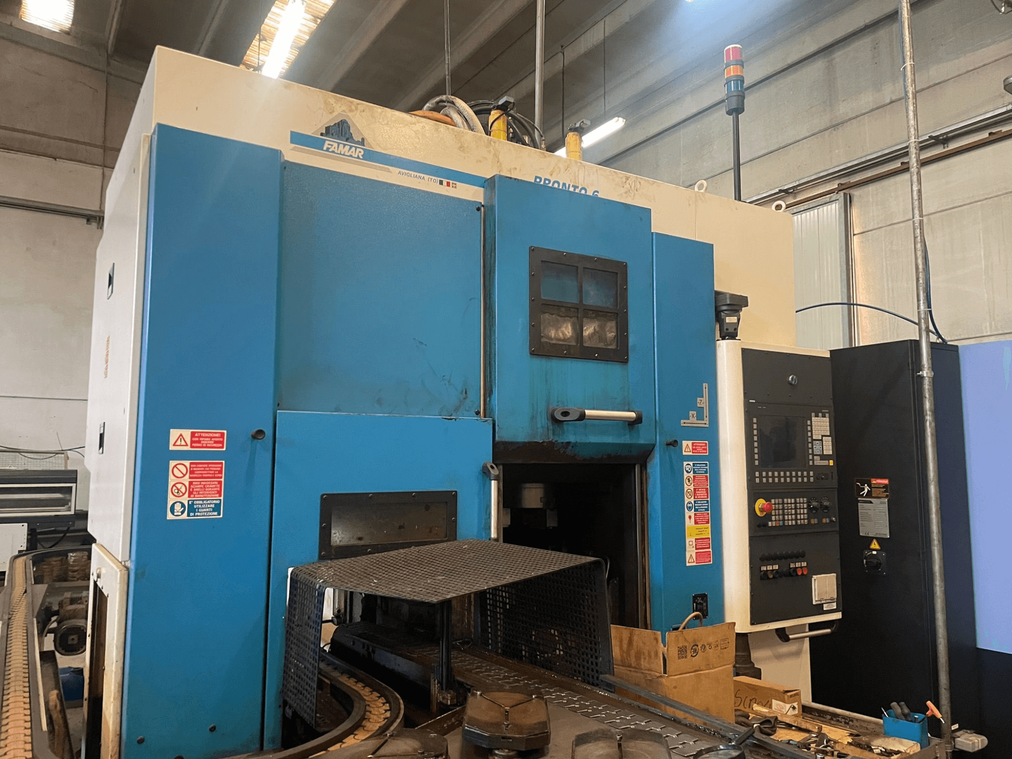 Famar Pronto 6 vertical turning machine in a workshop, side view, showing control panel, operational features, and safety labels.