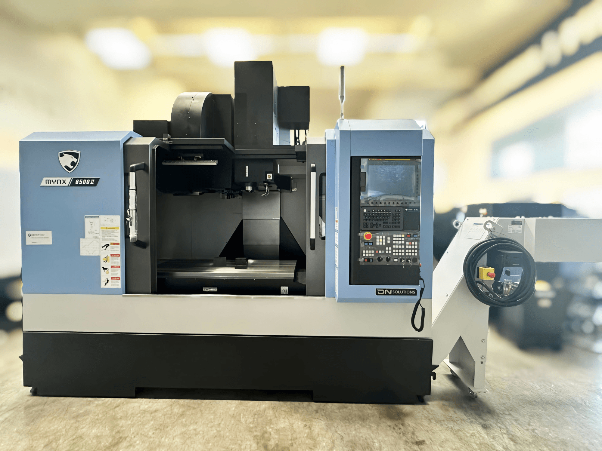 Vertical machining center DN SOLUTIONS MYNX 6500 II, front view, showcasing control panel and open machining area.