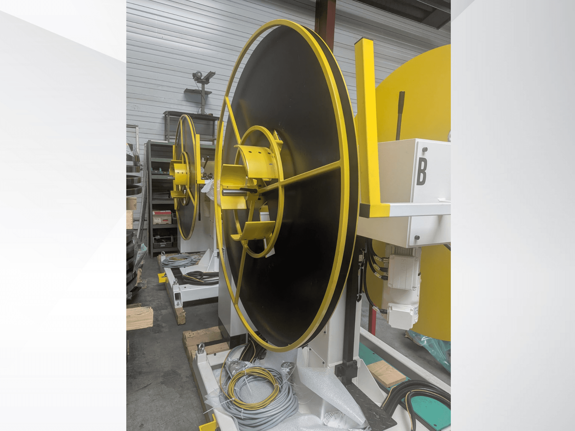Large industrial spool, model XYZ, with a black surface and yellow accents, shown from a side view, featuring electrical connections.