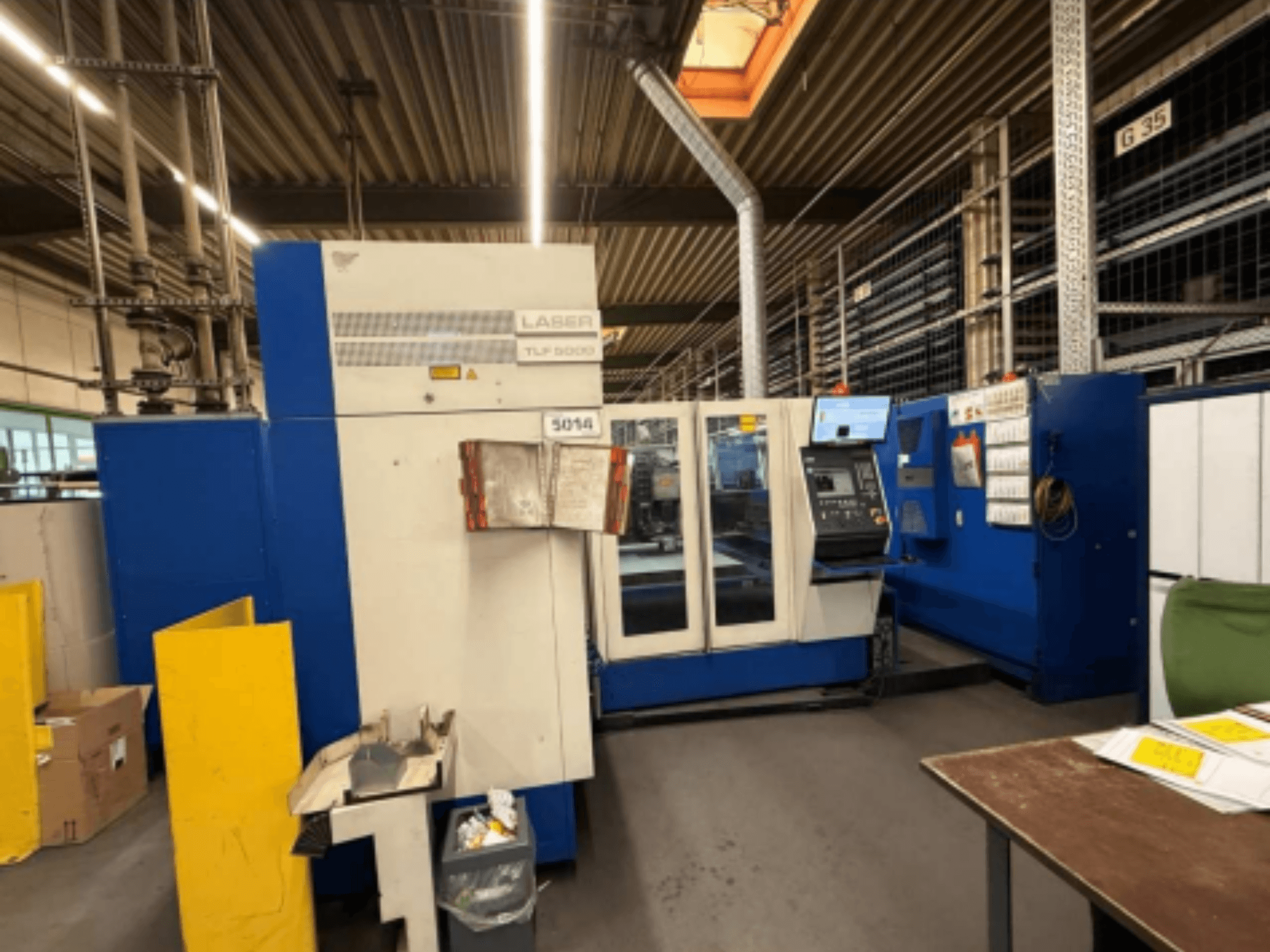 Front view of TRUMPF Trumatic L 3050 CO2 Laser Cutting Machine, showcasing control panel and operational features in a workshop.