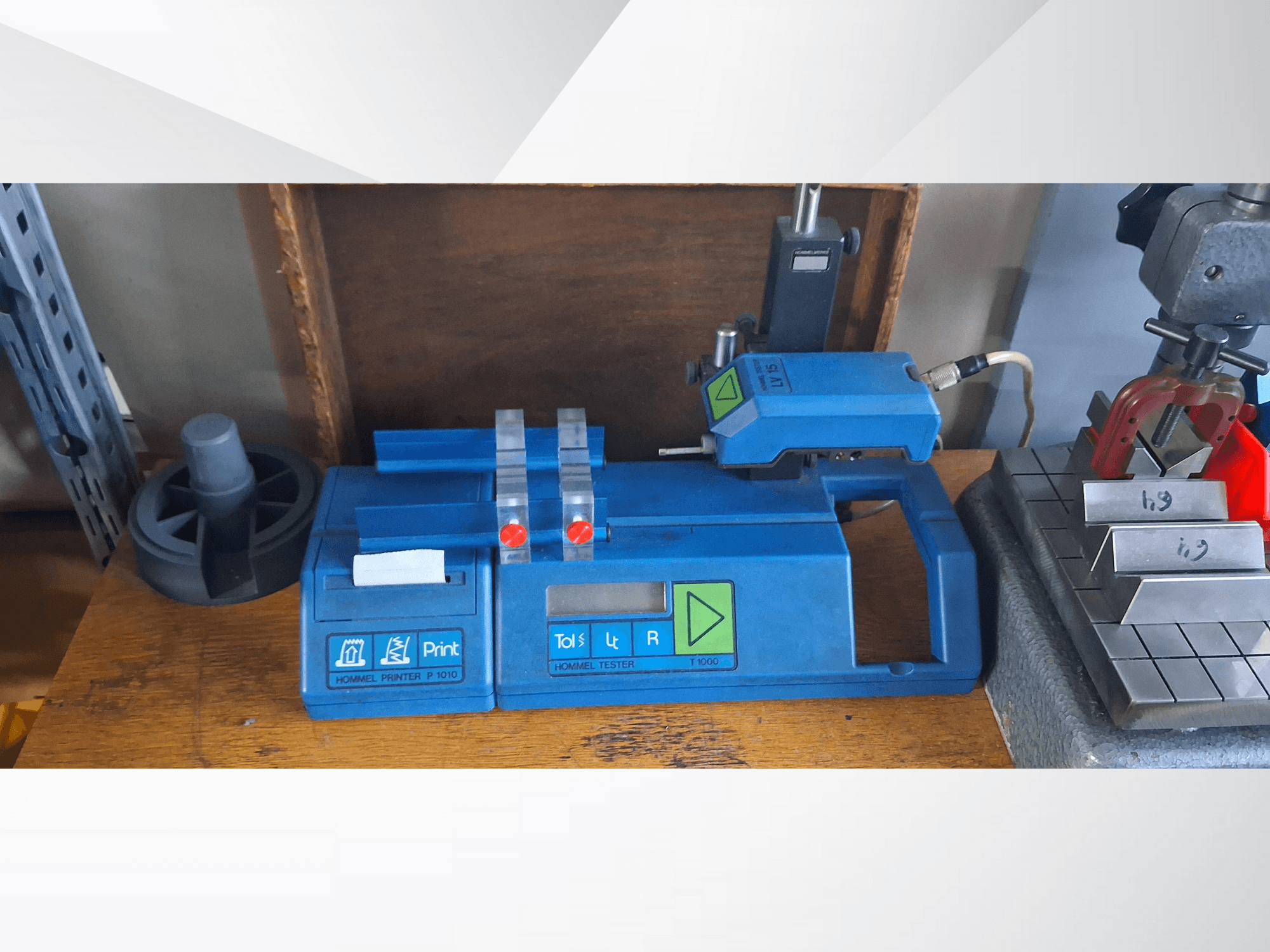 Hommel Printer P 1010 and Tester T1000 in a side view, featuring blue casing, buttons, and red indicators, on a workbench.