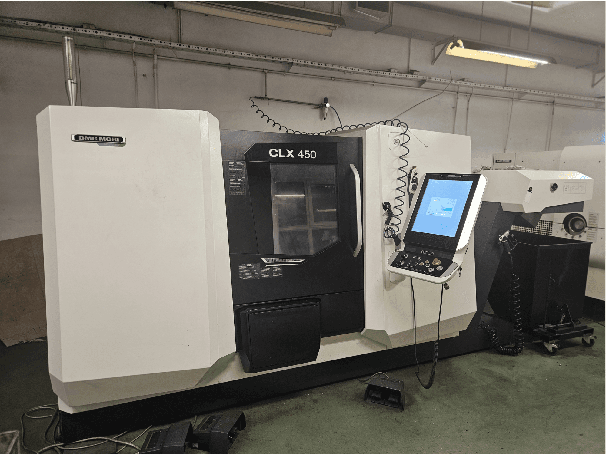 DMG MORI CLX 450 CNC machine in front view, featuring a control panel and touchscreen display, set in a workshop environment.