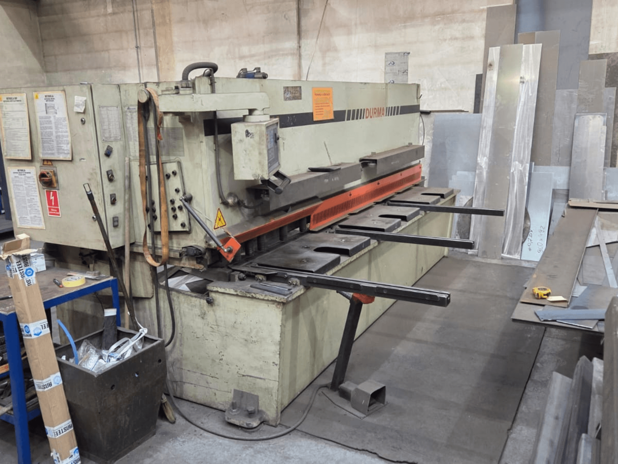 Hydraulic shearing machine Durma SB 3060, front view, showing controls, cutting blade, and metal sheets in workspace.