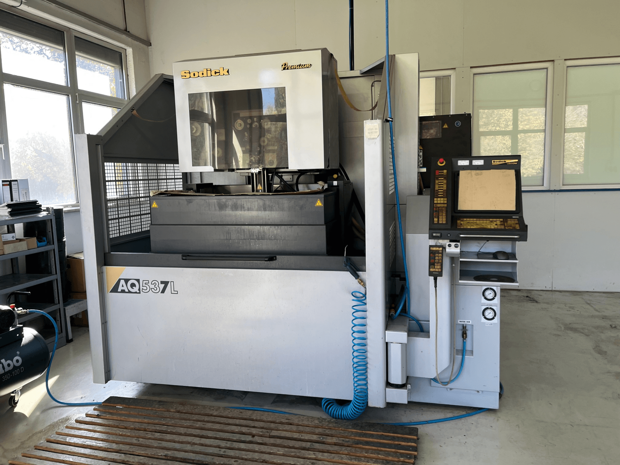 Sodick AQ537L electrical discharge machine (EDM) in front view, featuring control panel, water cooling lines, and workspace.