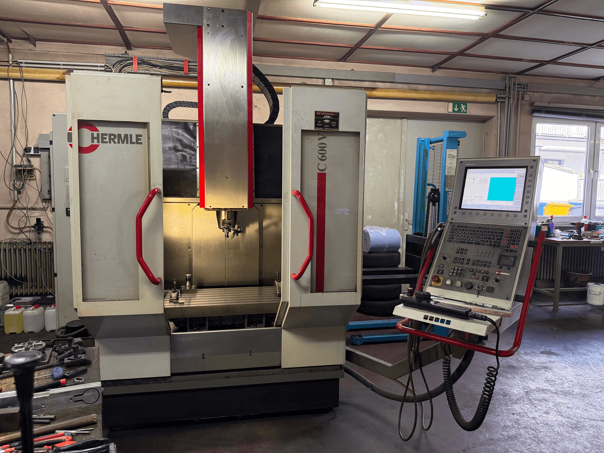 Hermle C 600 CNC milling machine from a front view, featuring a control panel with numerous buttons, and a spacious work area.