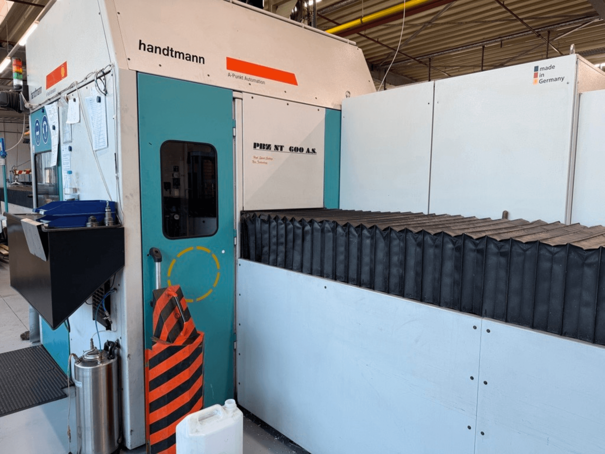 Front view of Handtmann PBZ NT 600 AS gantry milling machine, featuring a dark work surface and safety barriers.