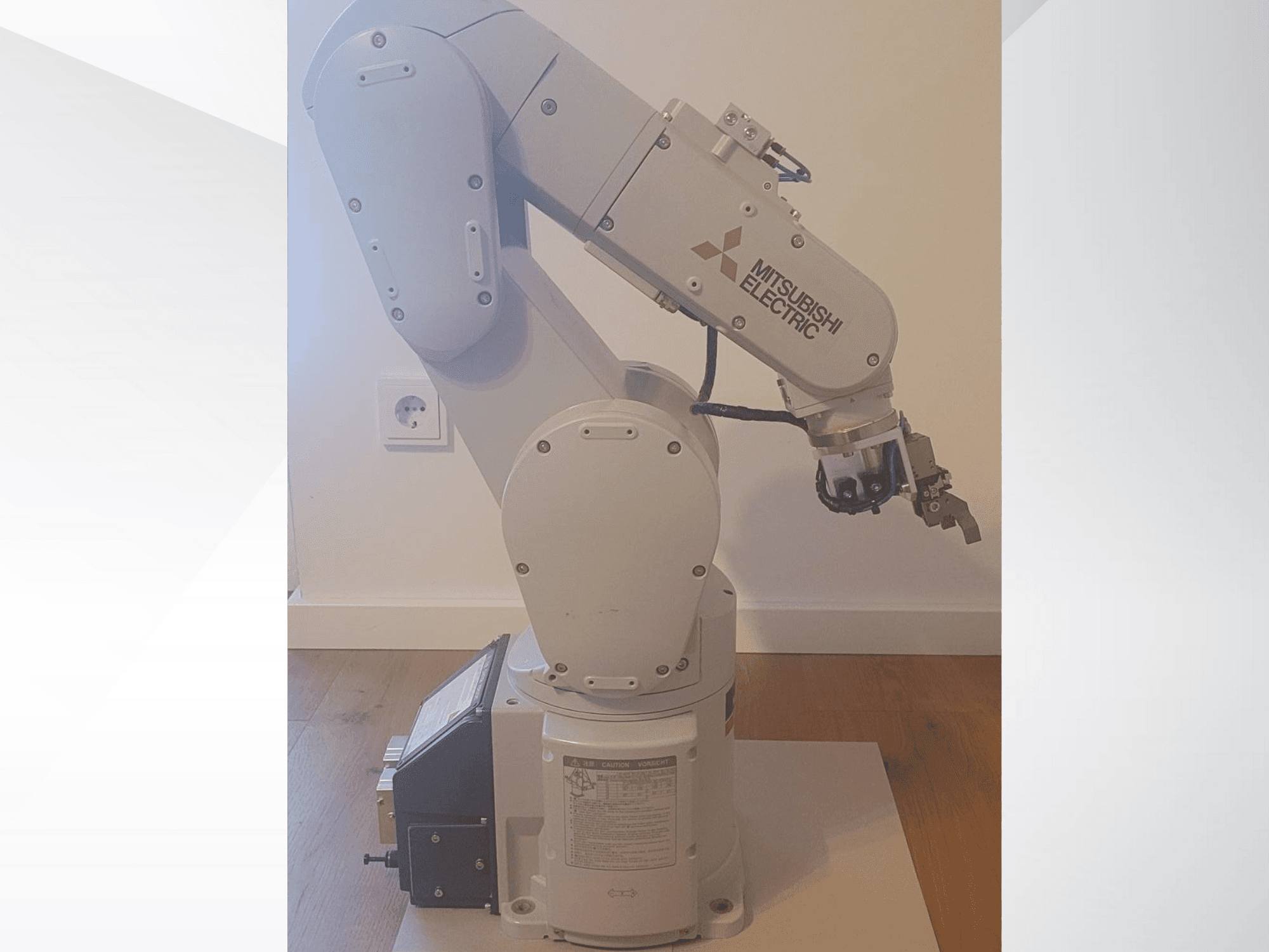 Mitsubishi Electric robotic arm, side view, featuring a gripper and detailed control panel on the base for operation settings.