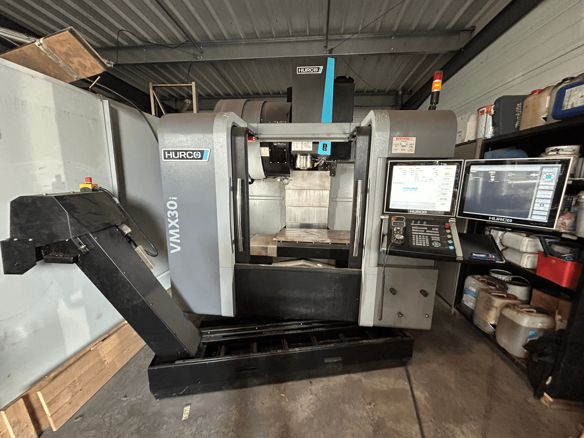 Hurco VMX30i vertical machining center, front view with dual monitors and controls, showcasing a clean working area.