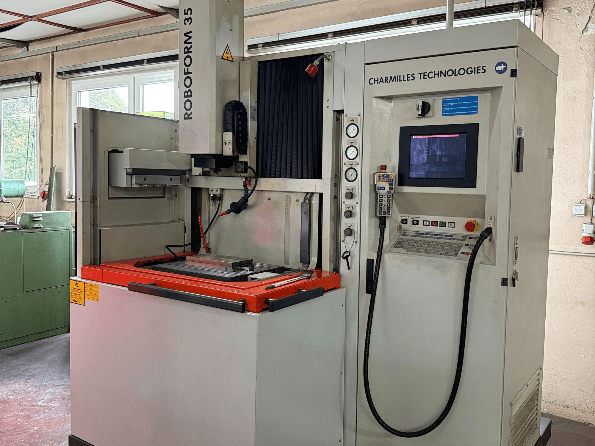 Charmilles Technologies Roboforn 35 machine, front view, showing control panel, mounted tools, and safety labels.