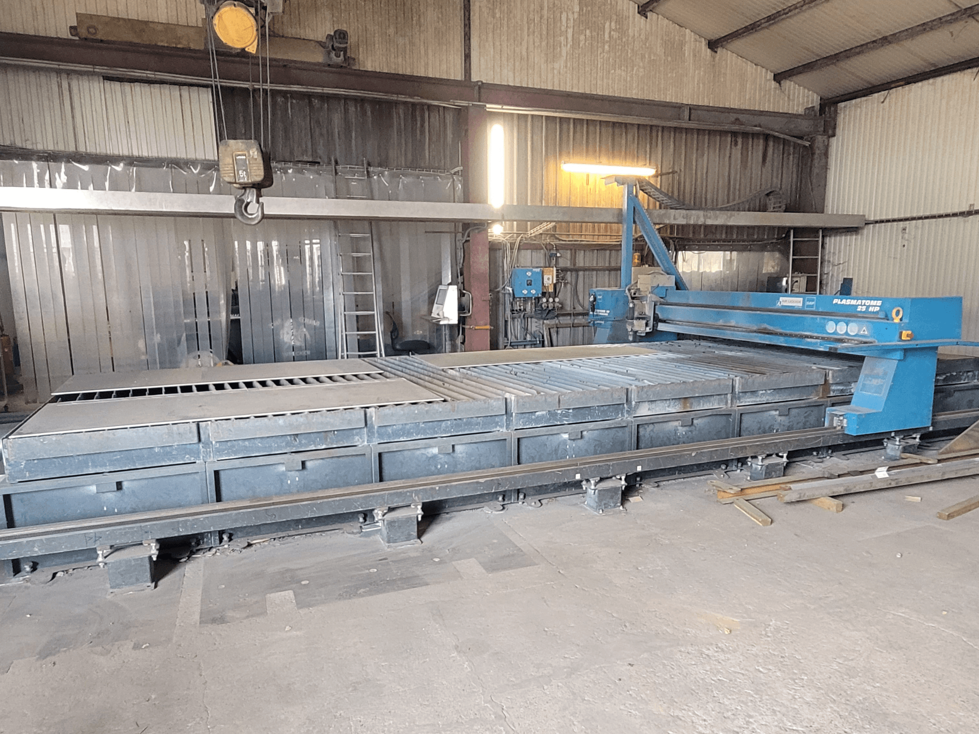 SAF Plasmatone 25Hp plasma cutting machine, side view, showcasing the cutting bed and operational components in an industrial setting.