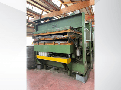 Manni hydraulic press, side view, featuring green metal body, yellow base, and multiple hydraulic lines visible.