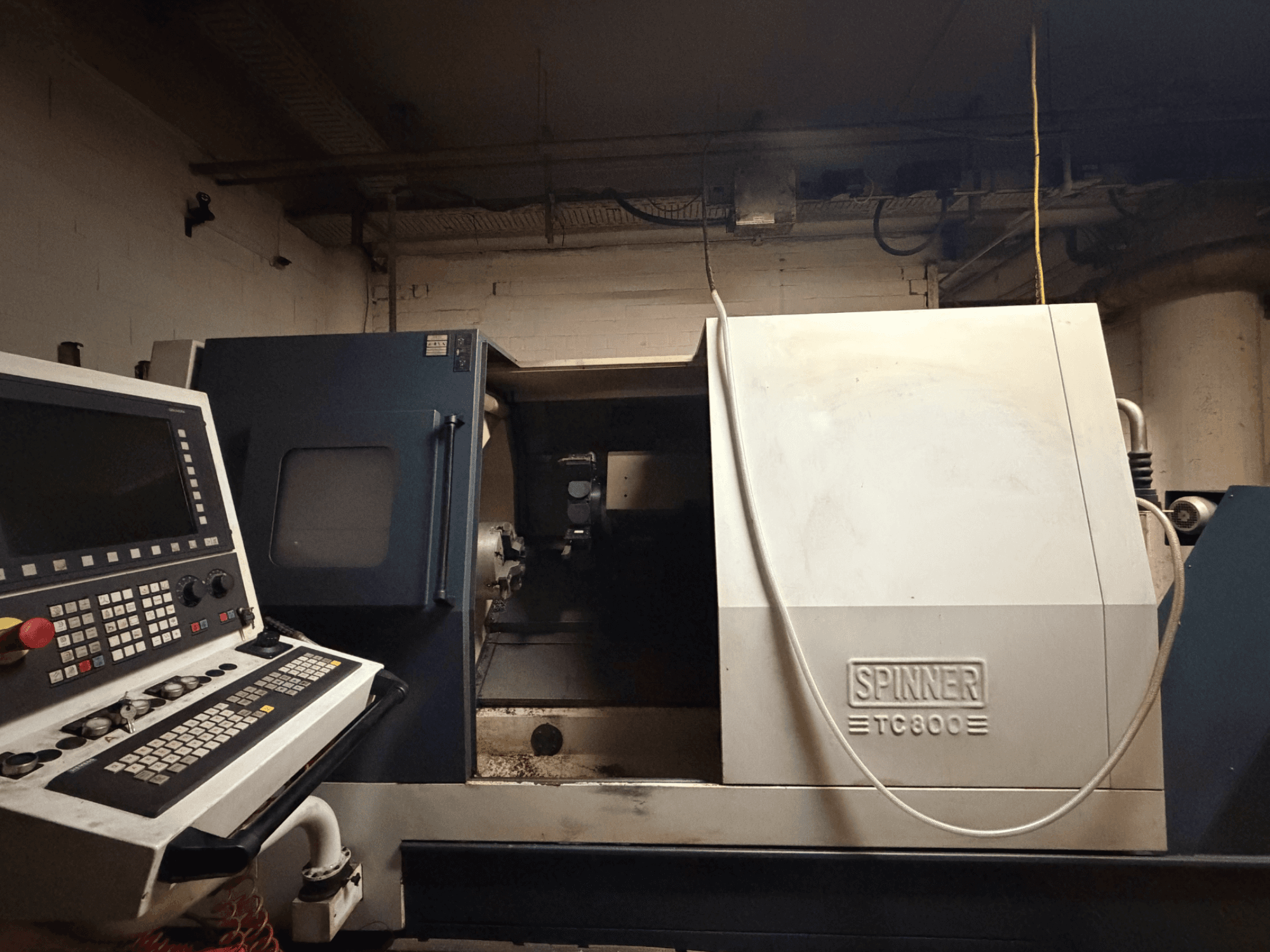 Horizontal turning machine SPINNER TC800, front view with control panel visible and machine interior slightly exposed.