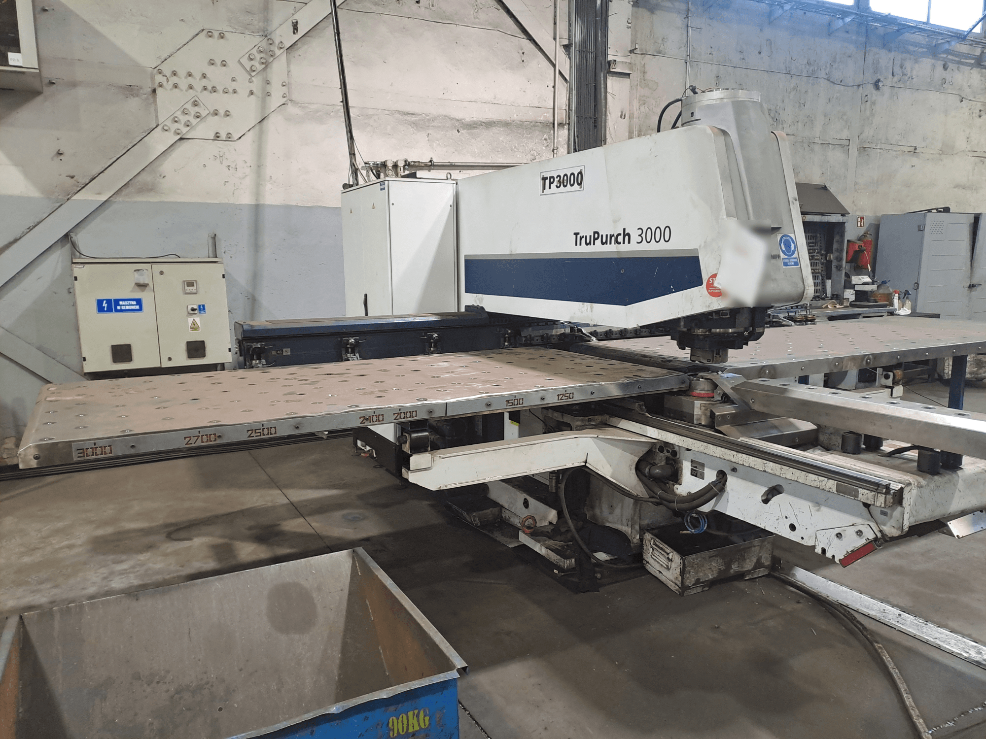 TruPunch 3000 CNC machine shown from the front, with a large metal plate and measurement markings, in an industrial setting.