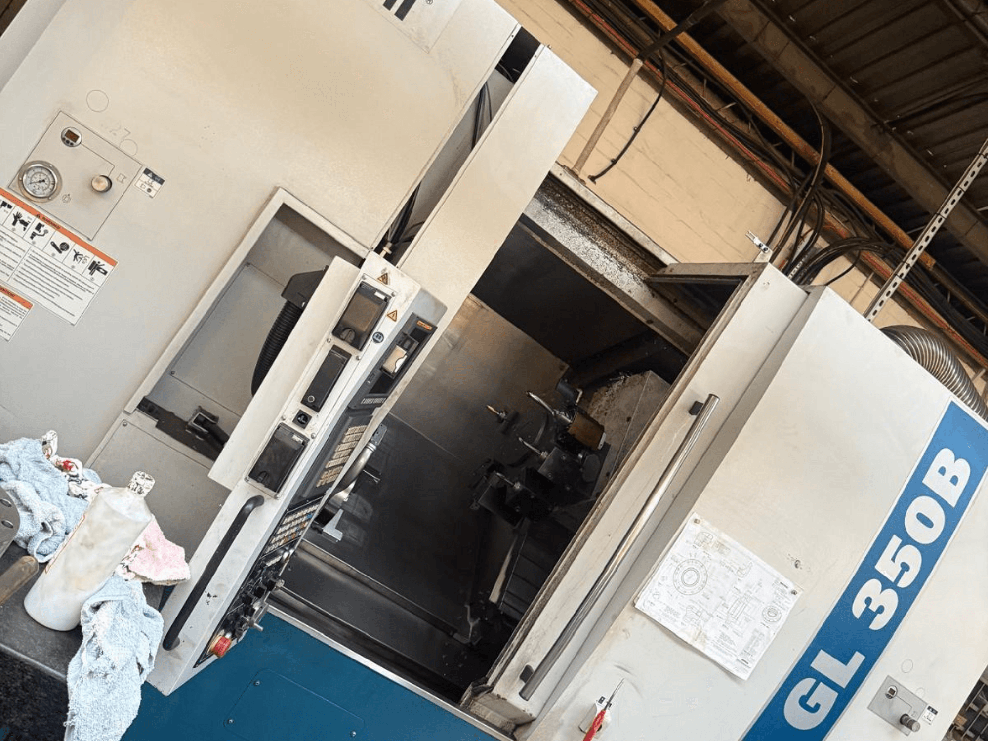 Horizontal turning machine Romi GL 350B, front view, featuring a control panel and opened door revealing the interior.