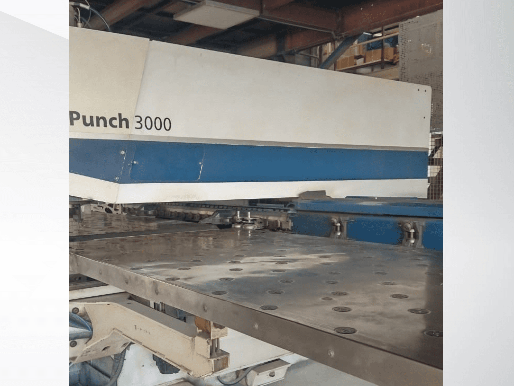 Punch 3000 machine in a workshop, front view, showcasing a large, flat metal surface with multiple punch holes.