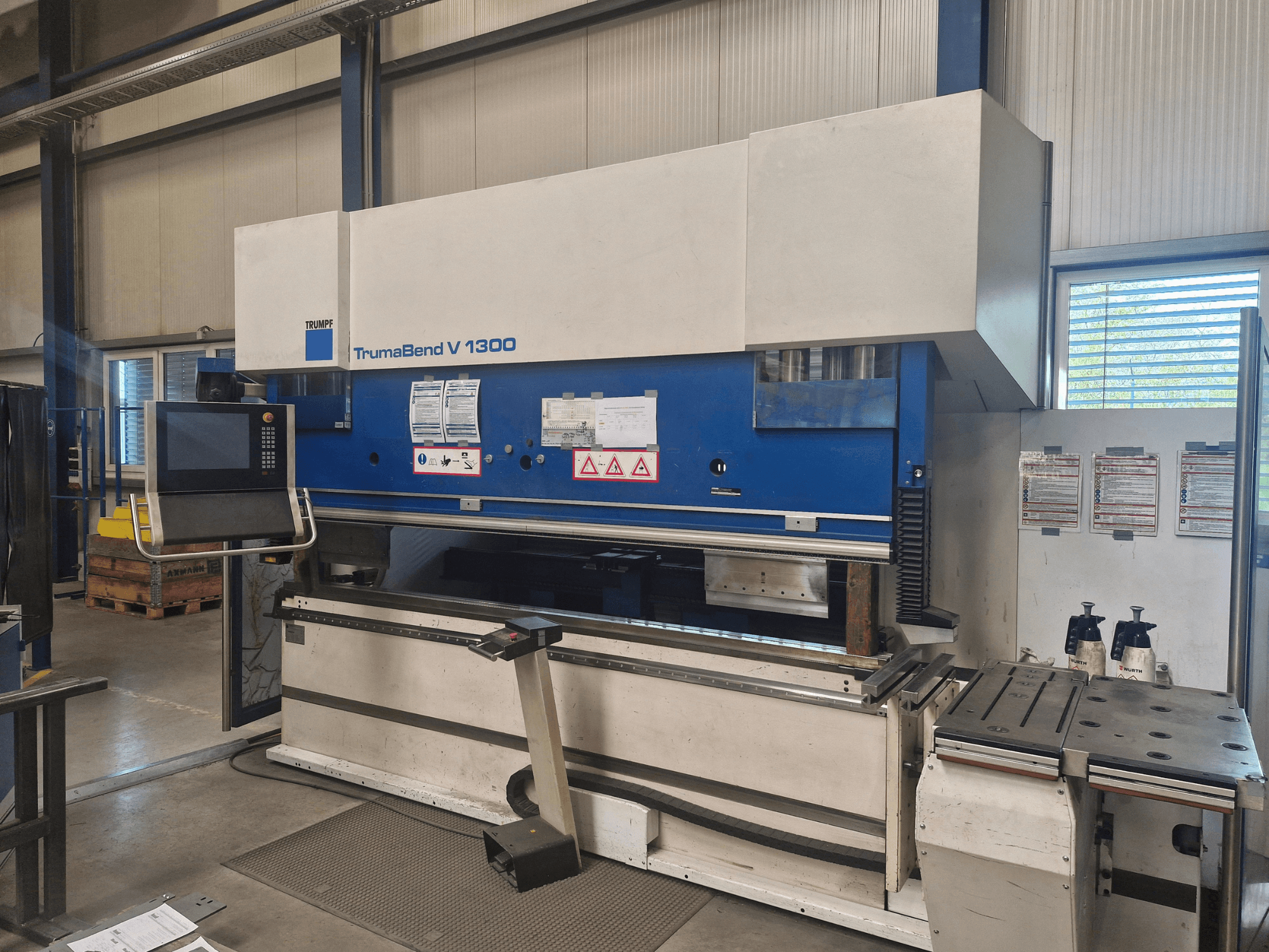 TRUMPF TrumaBend V 1300 press brake in a workshop, front view showing control panel, bending area, and safety features.