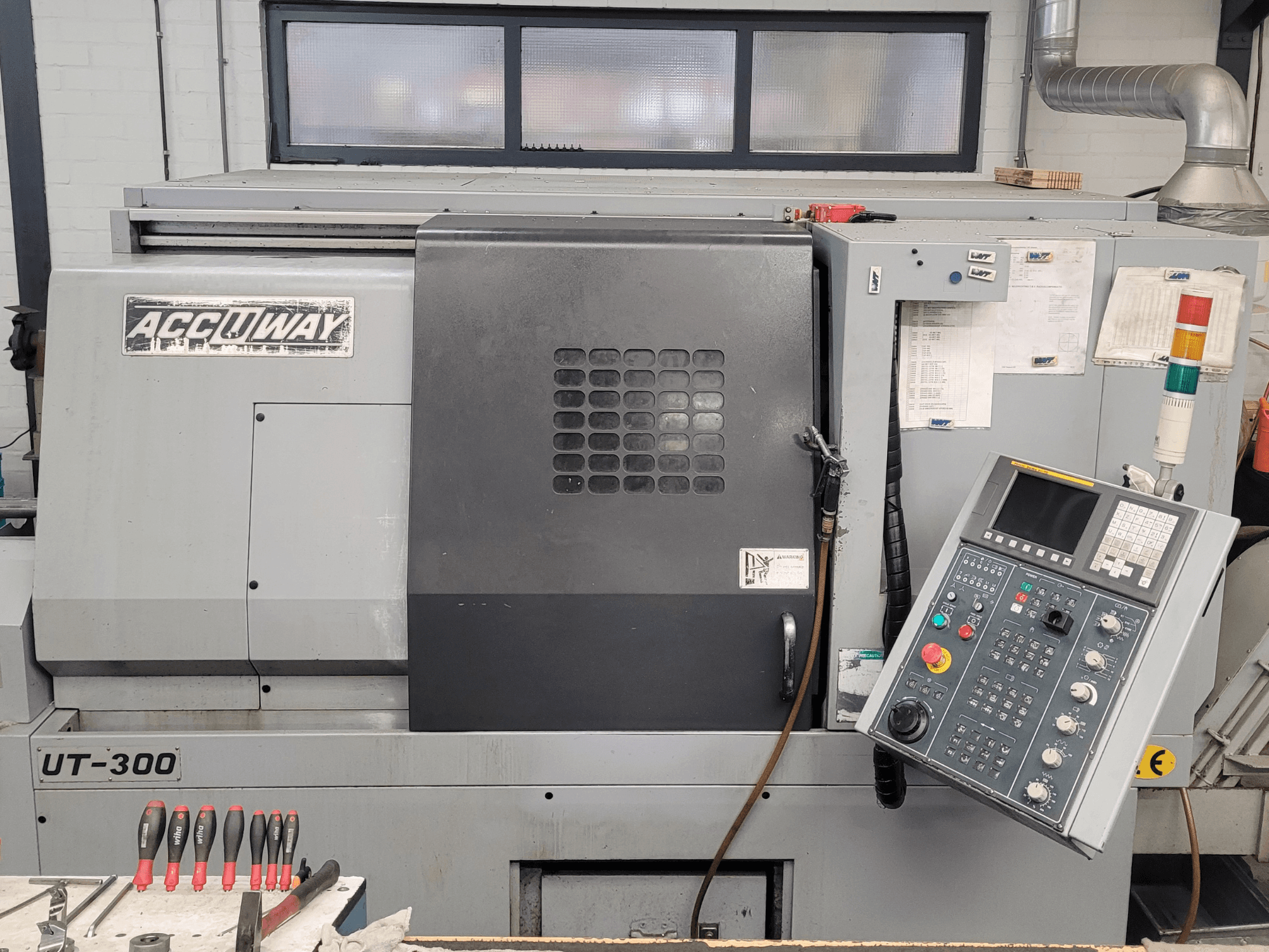 Accuway UT-300 CNC machine in front view, featuring a control panel and various operational buttons, in a workshop setting.