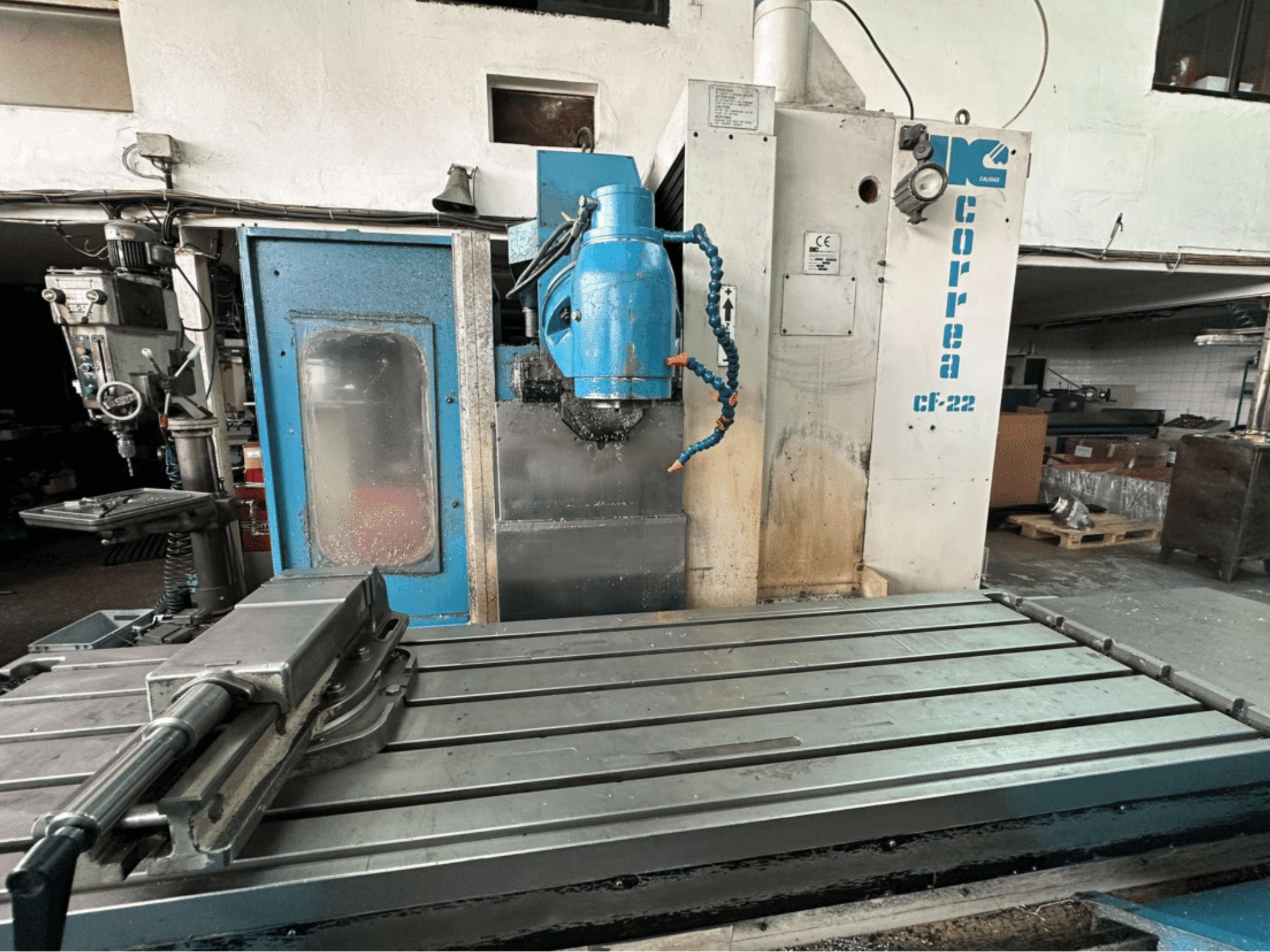 Correa CF-22 milling machine, front view; features a metal worktable and blue and white control panel with knobs.