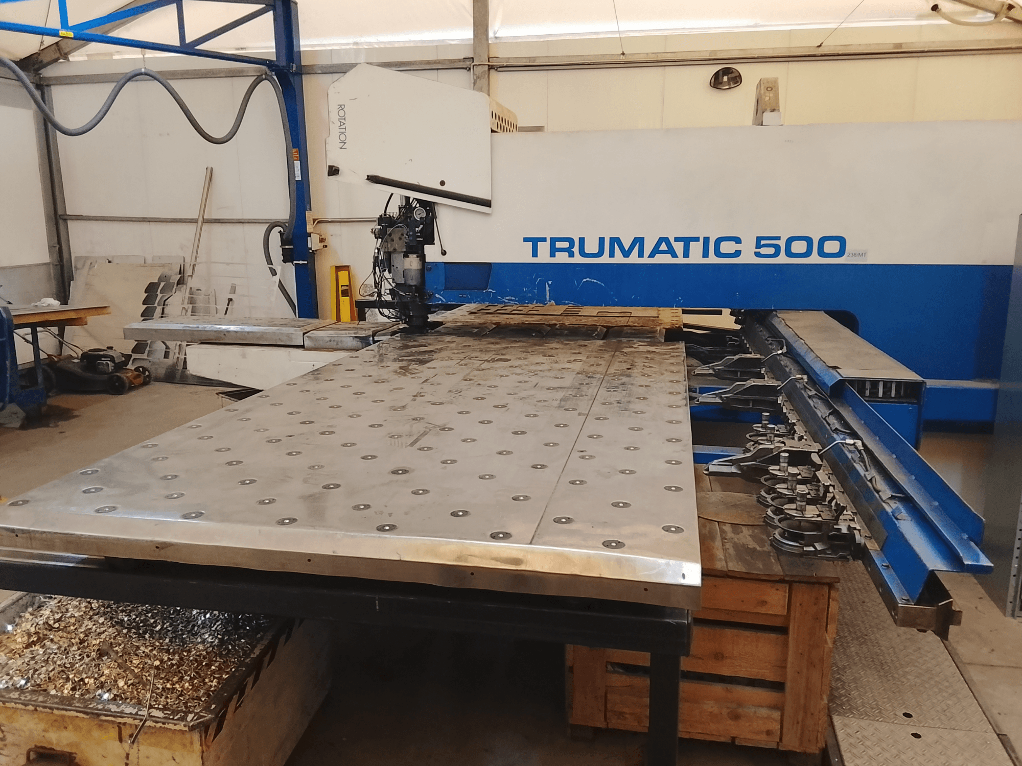 Trumatic 500 CNC machine, top view, featuring a large metal cutting table with mounted tools and shavings underneath.