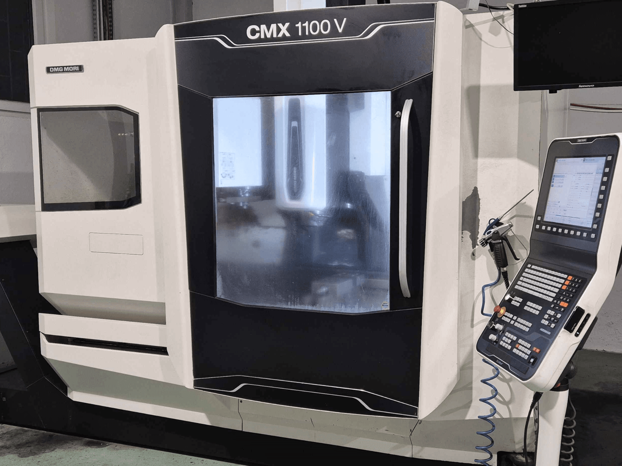DMG Mori CMX 1100 V, front view of CNC machine with control panel, digital display, and coolant setup visible.