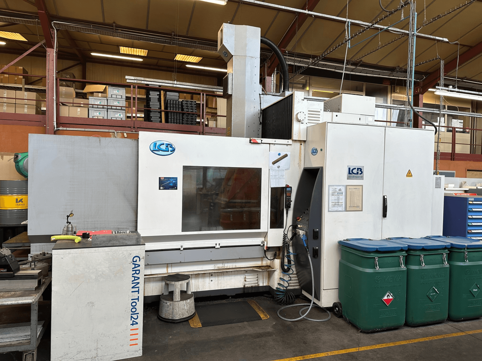 LGB CNC machine viewed from the front, with GARANT Tool24 workstation and green waste bins on the side.
