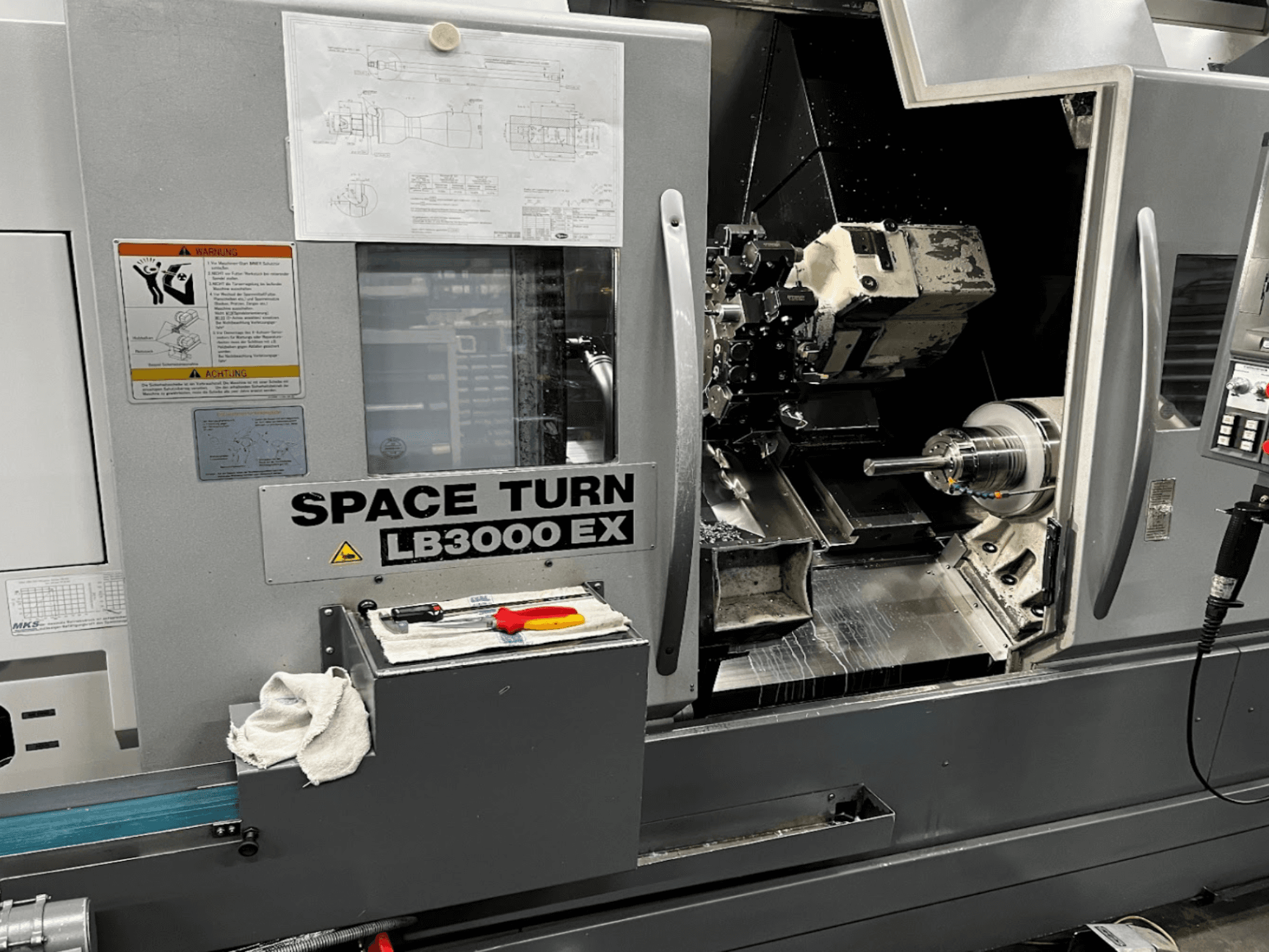 Okuma LB3000EX MYW horizontal turning machine, front view with control panel, tools, and workspace details visible.