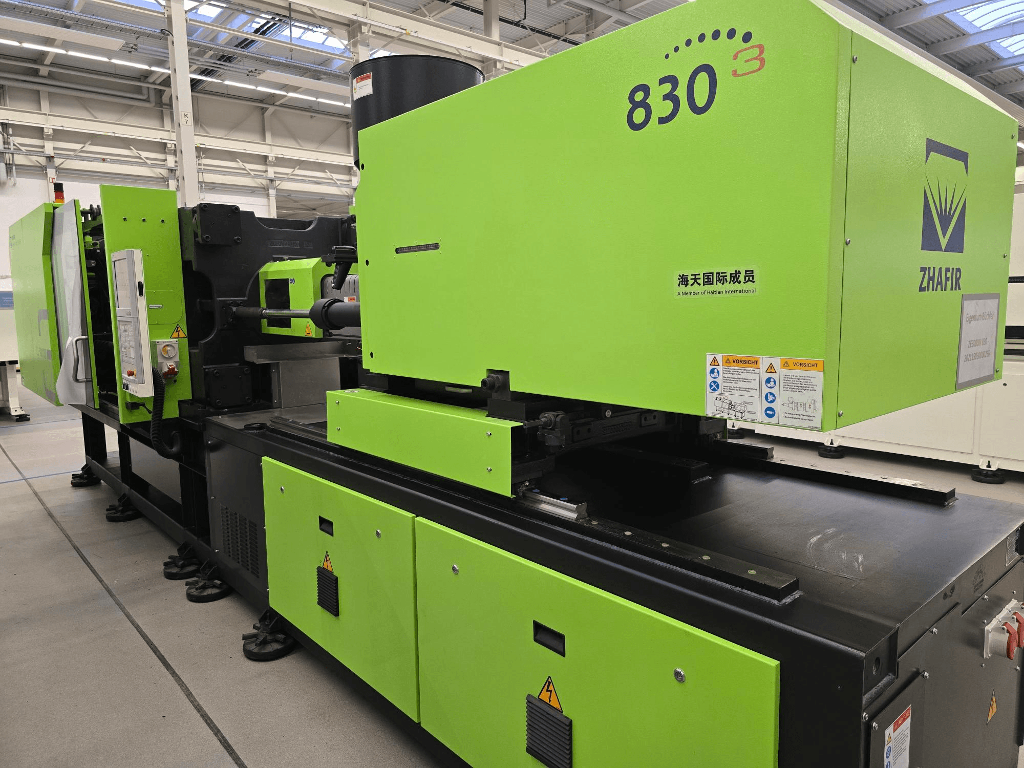 ZHAFIR ZERES III 3000/830/B5 electrical injection moulding machine, side view, with bright green casing and control panel visible.