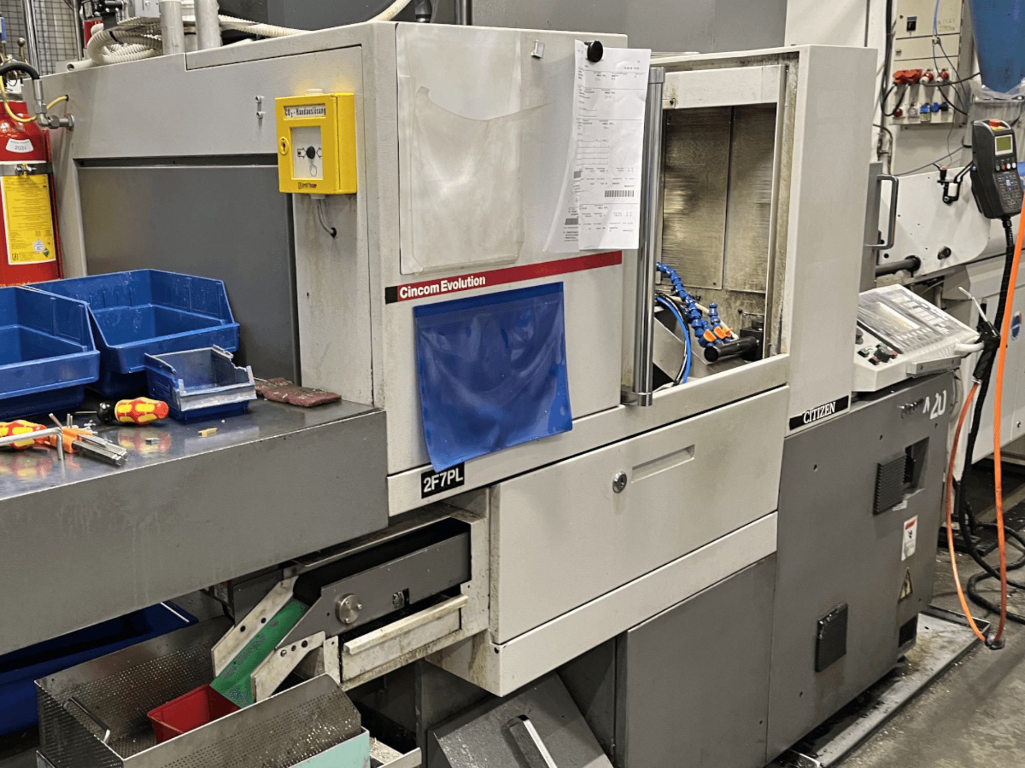 Cincom Evolution 2F7PL machining center, front view; features controls, tool bins, and a detailed operating panel.