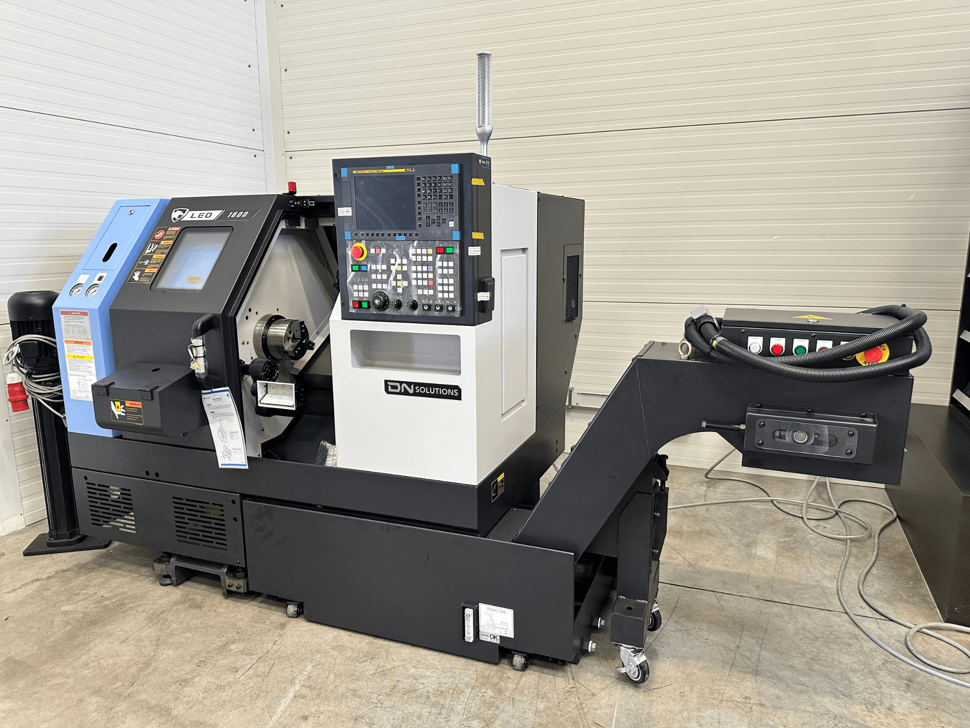 Front view of DN SOLUTIONS Leo 1600 turn-mill centre, featuring a digital control panel and tool holder, on a black base.
