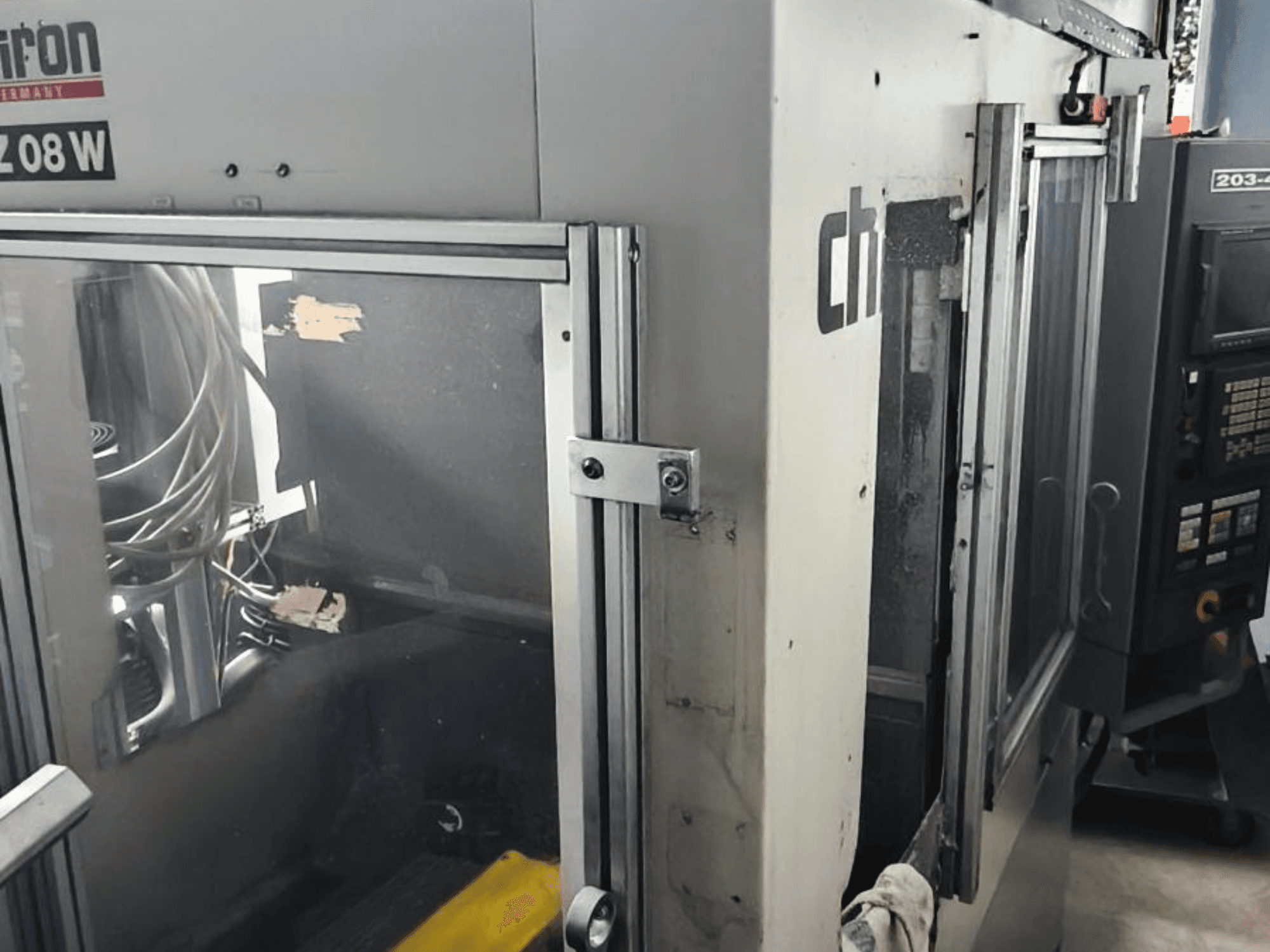 Vertical Machining Centre CHIRON FZ 08 W, front view showing control panel and partially open doors, with visible internal components.