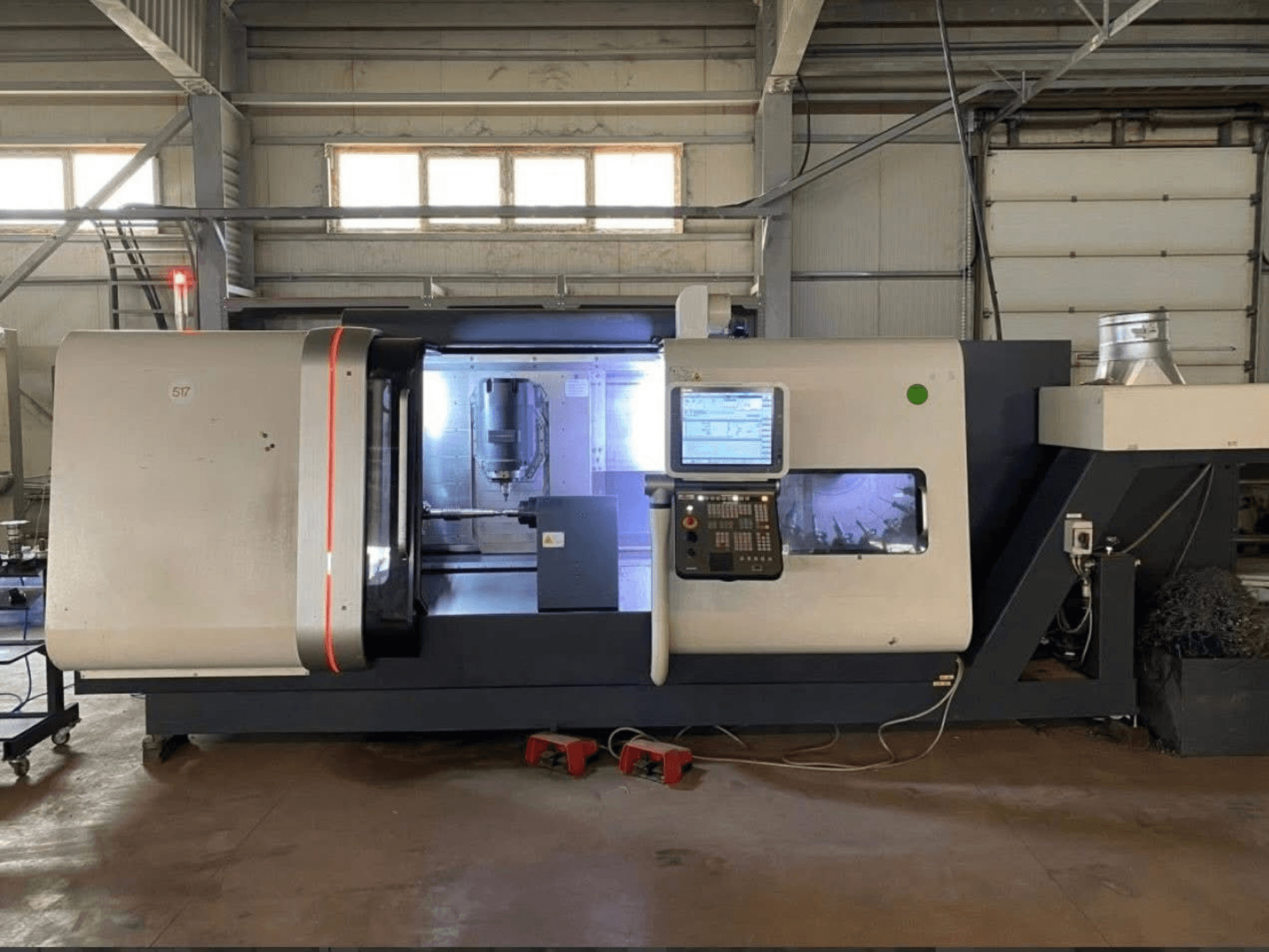 DMG MORI Beta 1250 TC turn-mill centre, front view with control panel, illuminated workspace, and cutting tools visible.