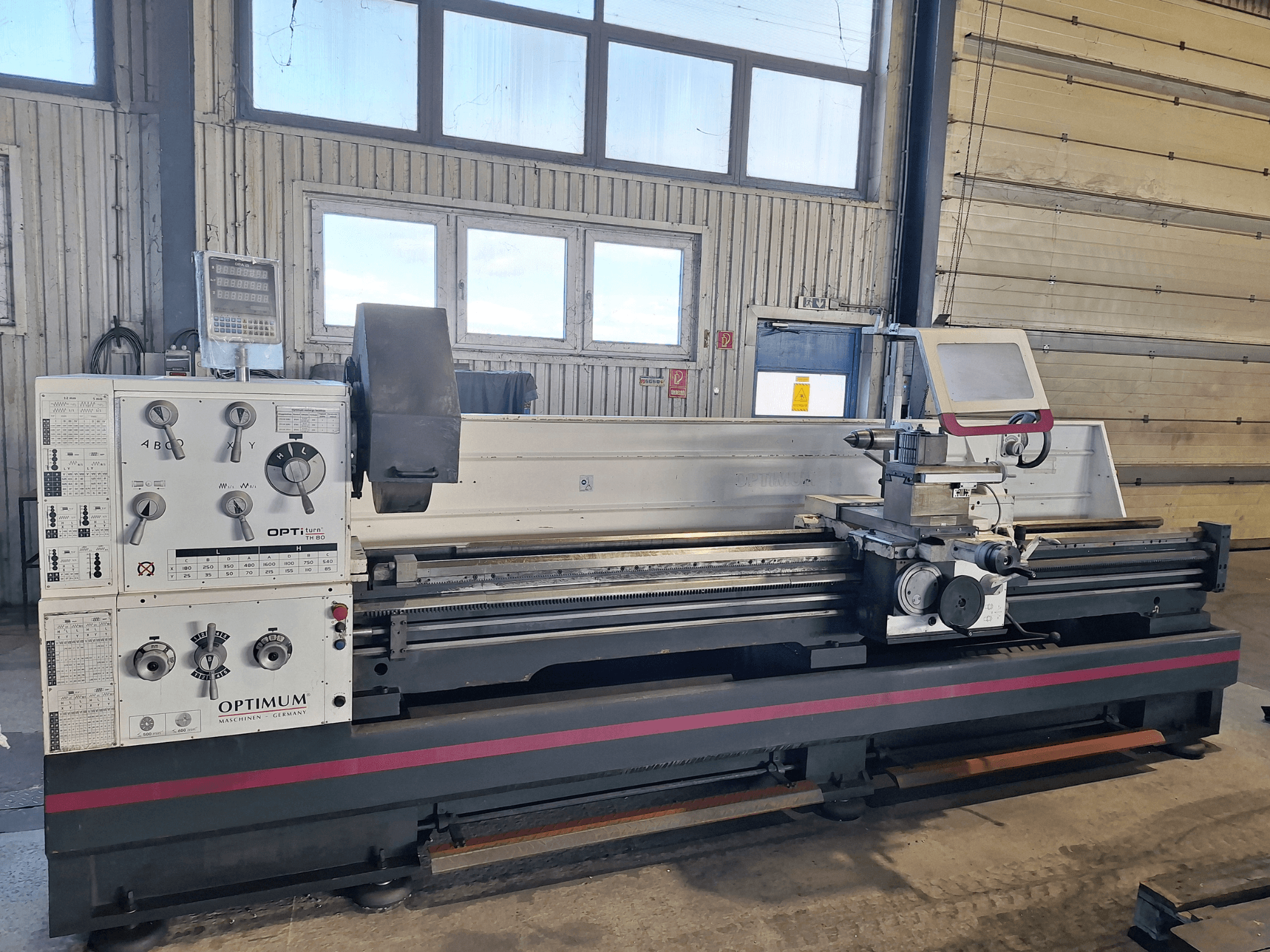 Optimum OptiTurn TH 8030D horizontal turning machine in side view, featuring control panel, tool holder, and sturdy base.