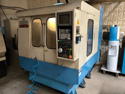 SPT-V30T CNC machine in blue and white, front view showing control panel, doors, and air hose. Perfect for precision machining.