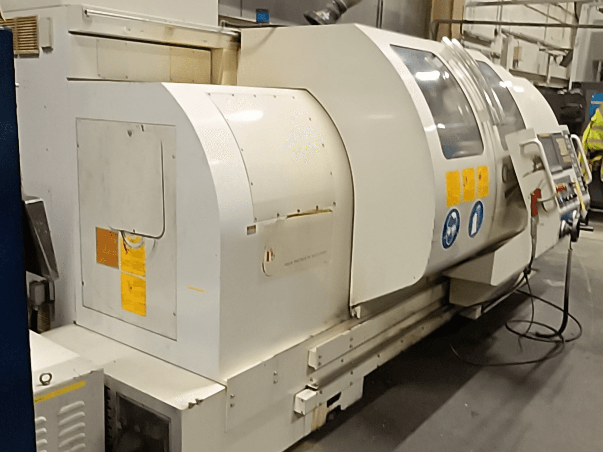 Horizontal turning machine MONDIALE BNC-2260XL, side view, featuring control panel and safety labels.