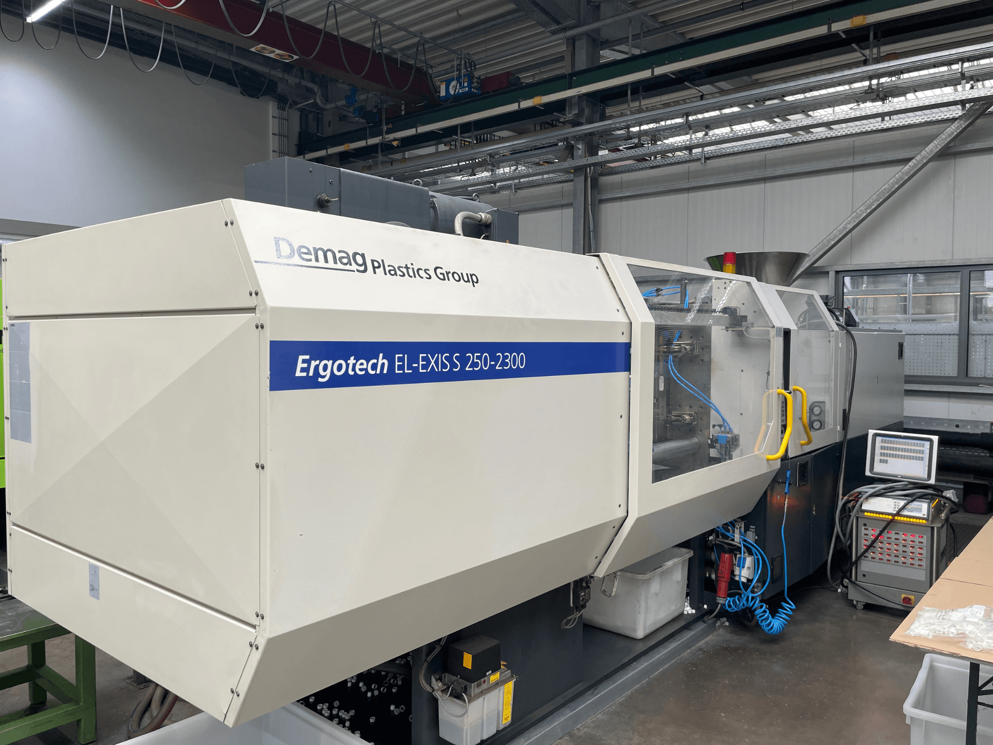 Demag Ergotech EL-EXIS S 250-2300 injection molding machine, side view, showcasing control panel and feeding system.