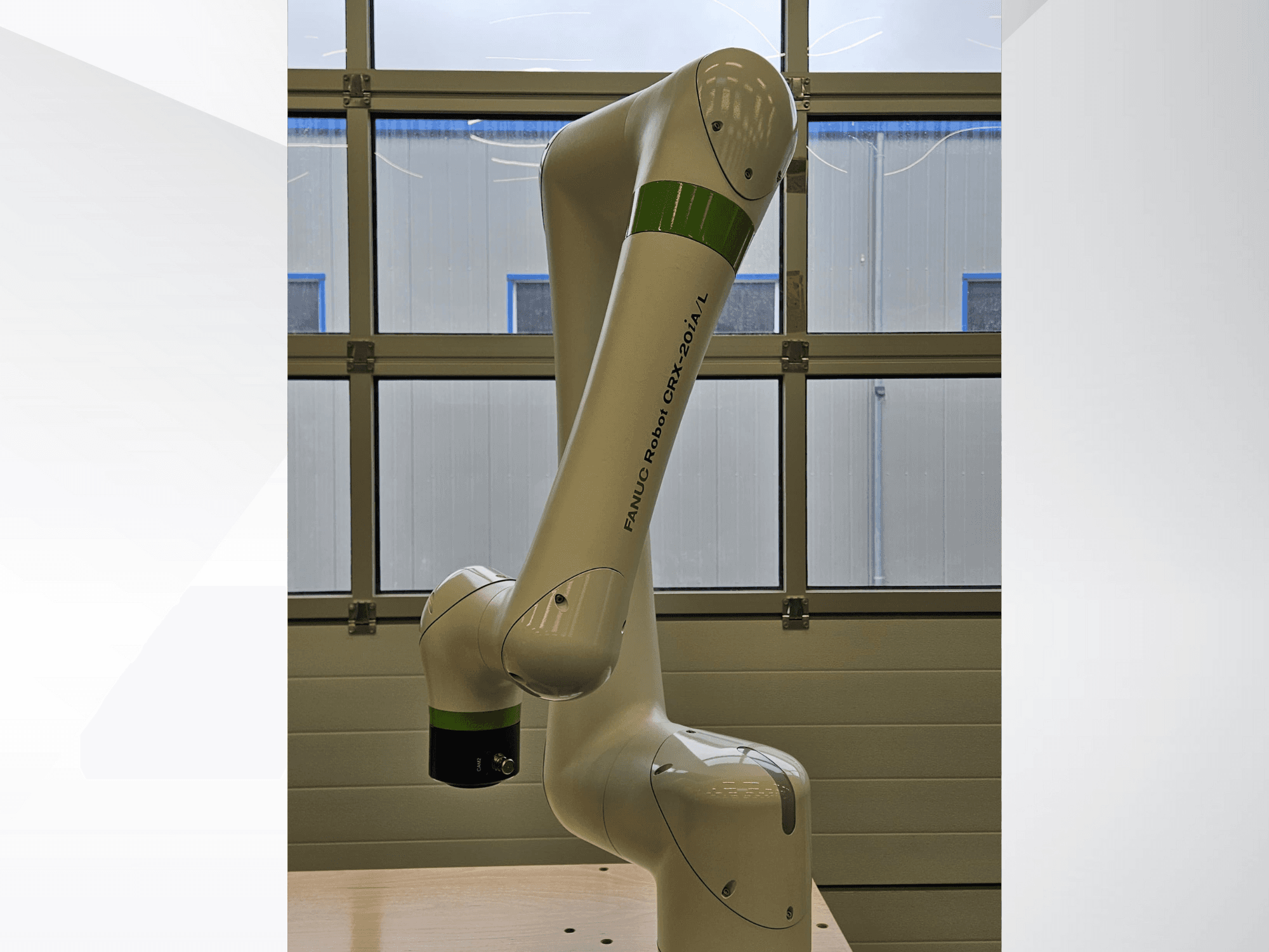 FRANKA ROBOT CRX-20A/L, side view, showcasing its articulated arm and green and black gripping end-effector.