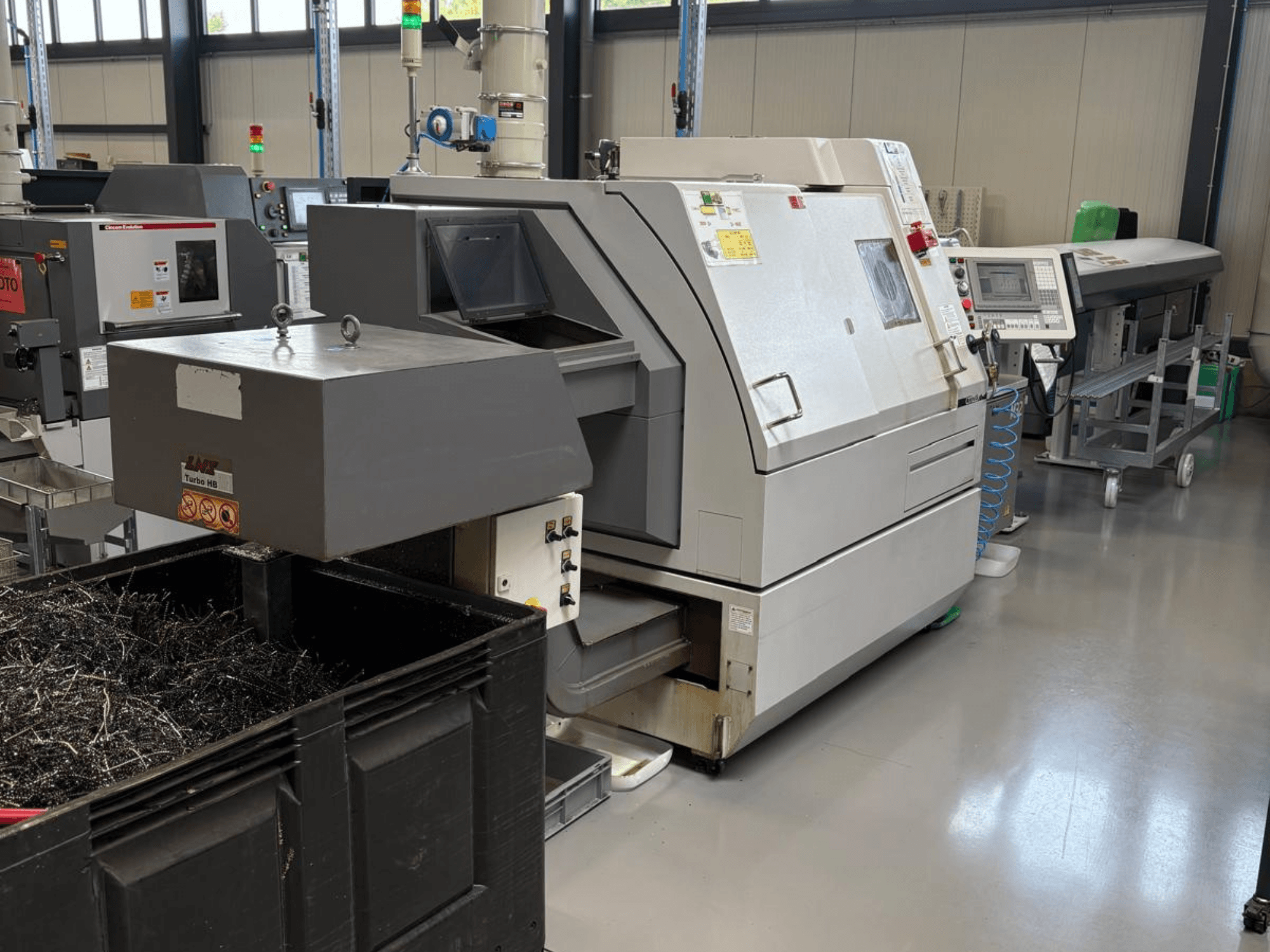 LTA Turbo H8 industrial machine, side view, with a large container for metal shavings and control panel in a factory setting.