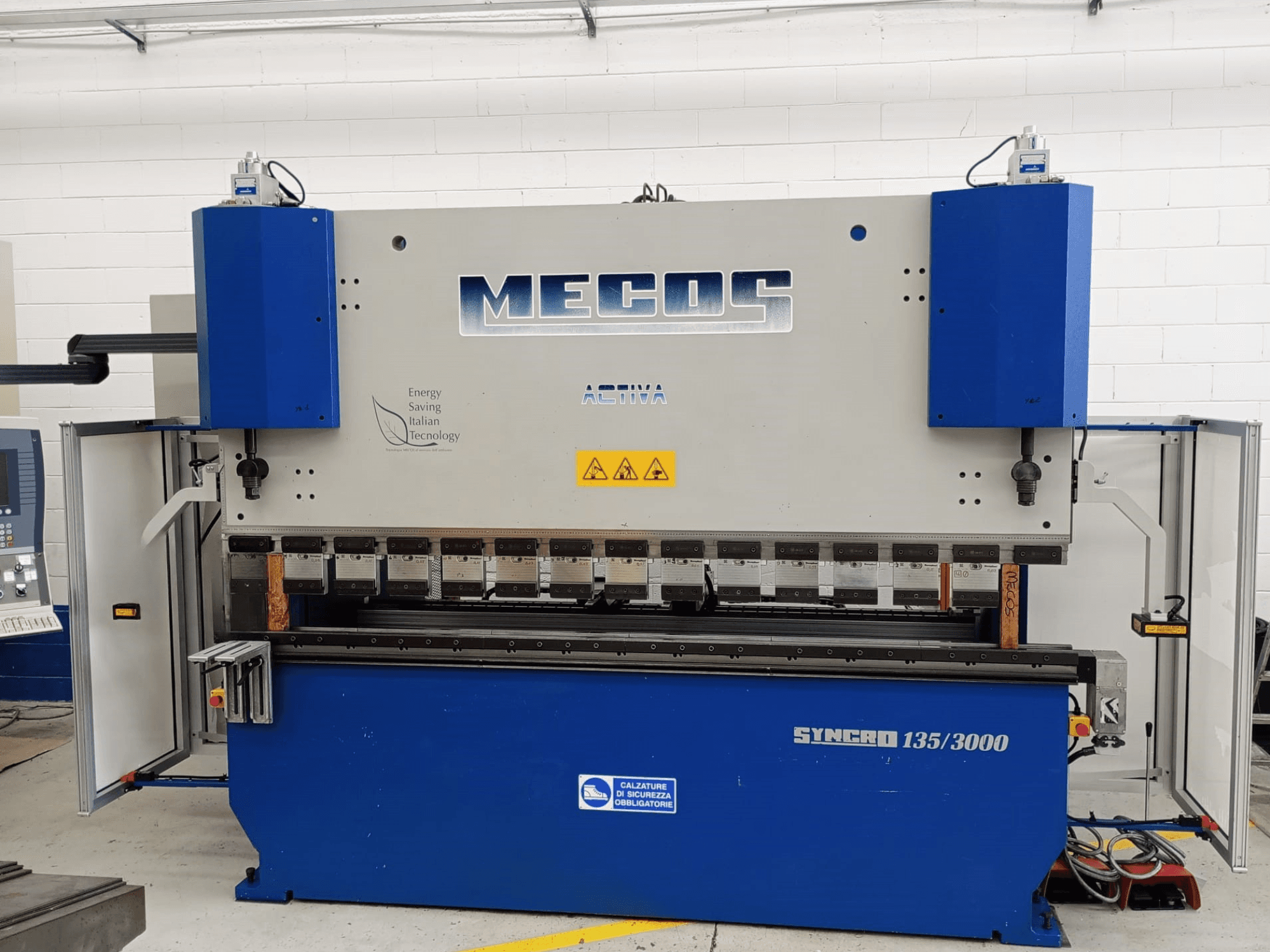 MECOS SYNCRO 135/3000 press brake front view, showcasing controls, bending tools, and safety features.