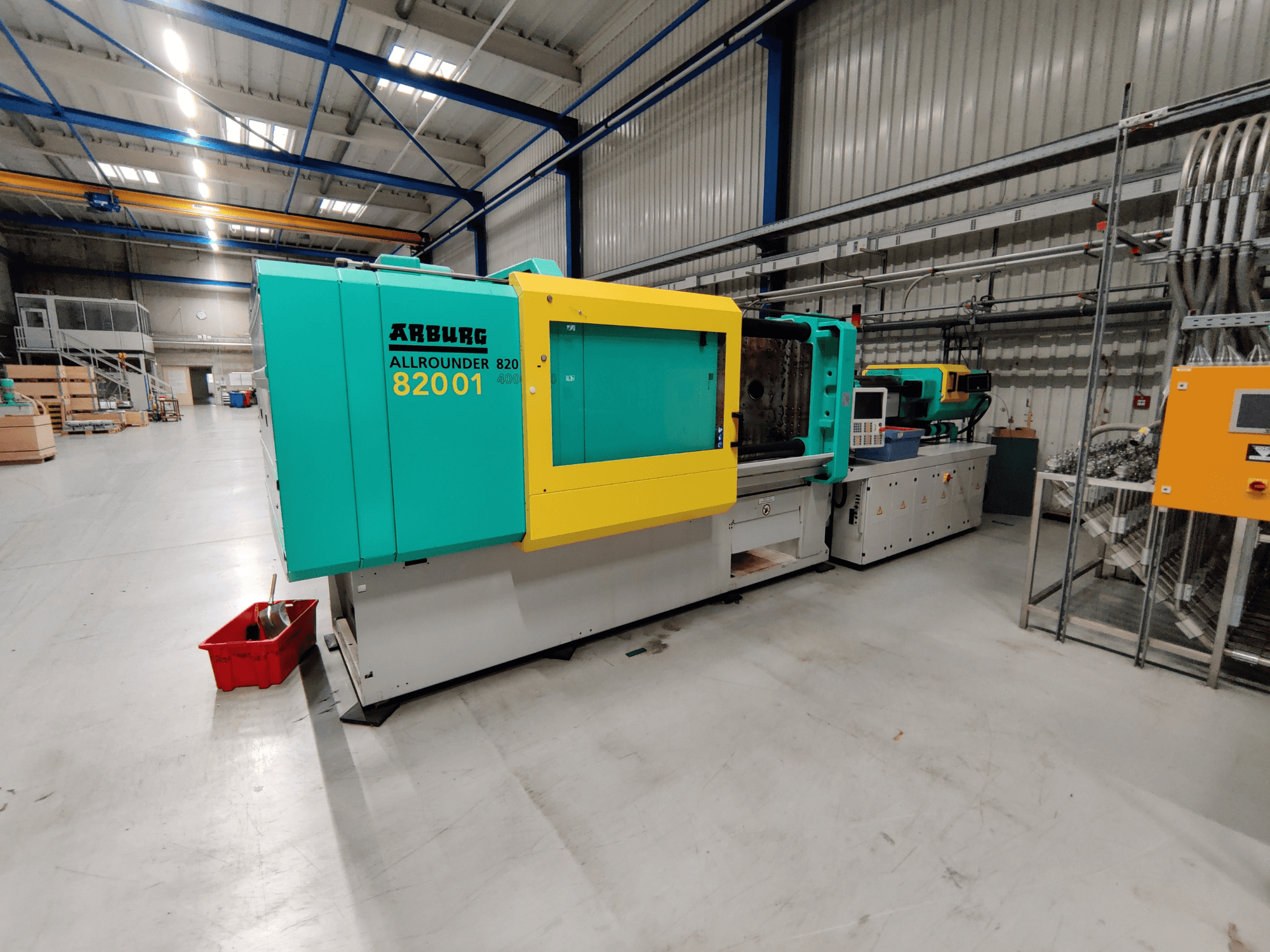 Front view of an Arburg 820 S 4000-2100 hydraulic injection moulding machine, featuring bright green and yellow panels.